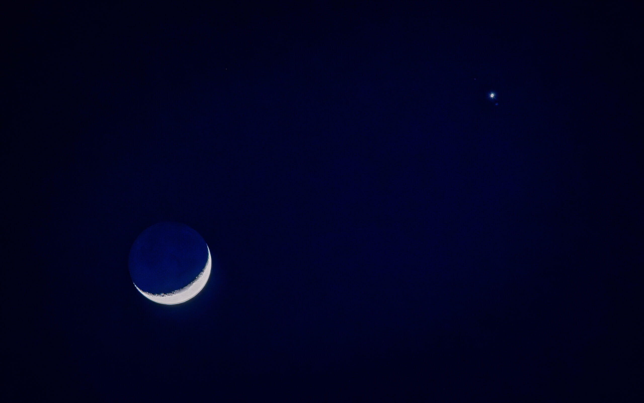 The crescent moon with Earthshine sits in a serene twilight sky with the brilliant glow of Venus in the distance. My Final Photo for February 1, 2025.