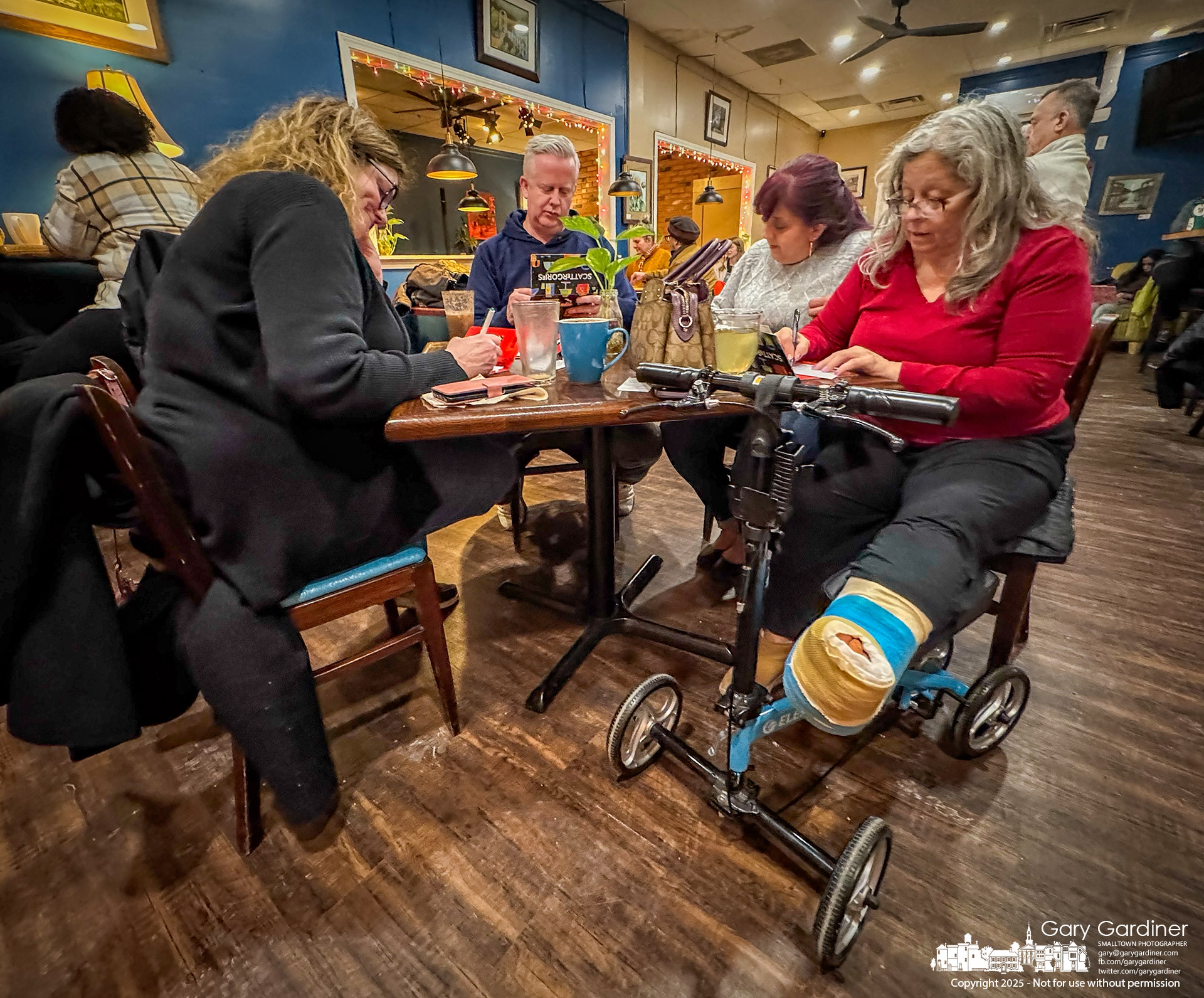 A foursome, including one person recovering from surgery, plays Scattergories while listening to artists performing at open mic night at Java Central in Uptown.