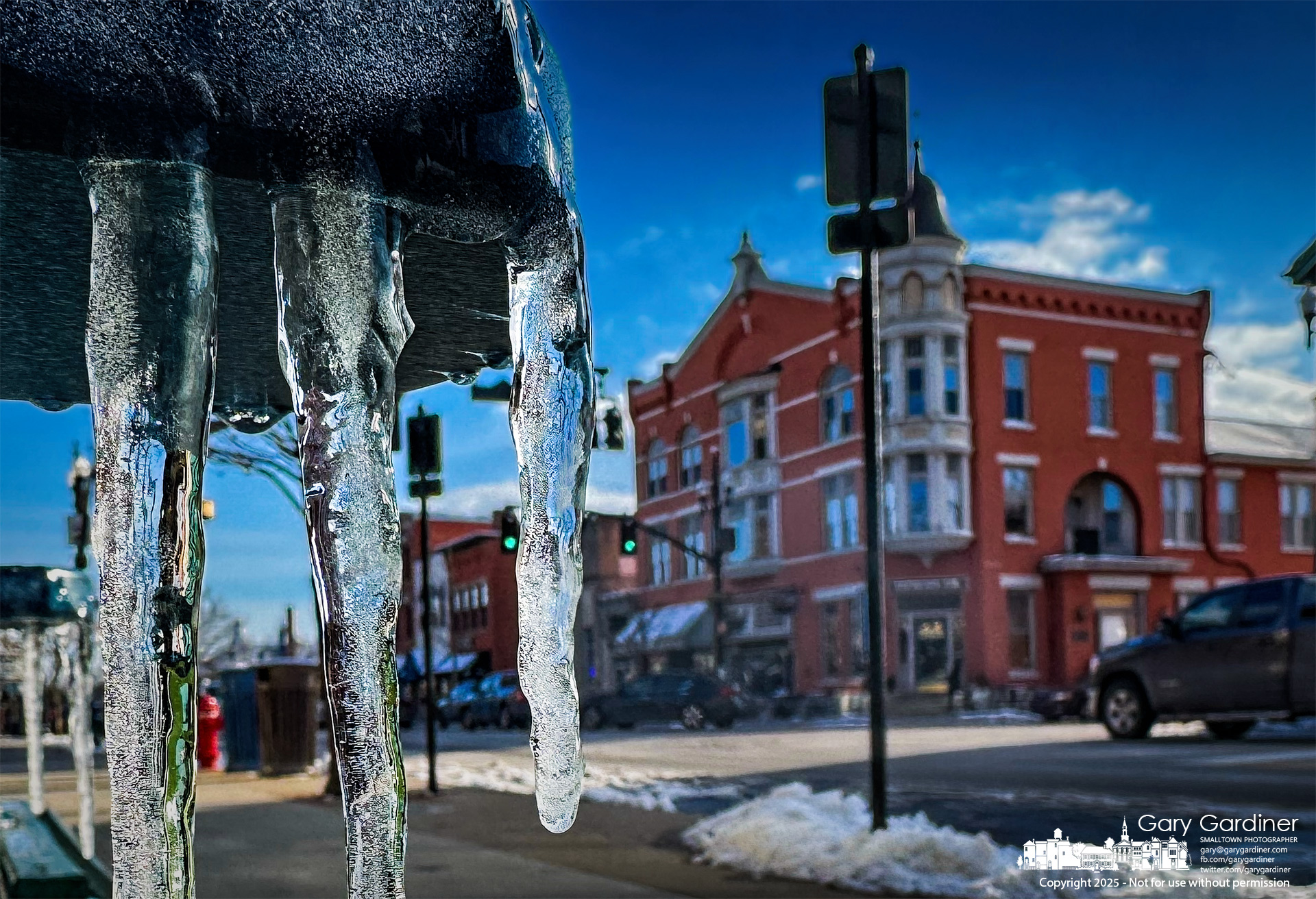 Icicles hanging from a chair in the foreground appear to loom large over the Holmes Hotel in Uptown Westerville. My Final Photo for February 18, 2025.