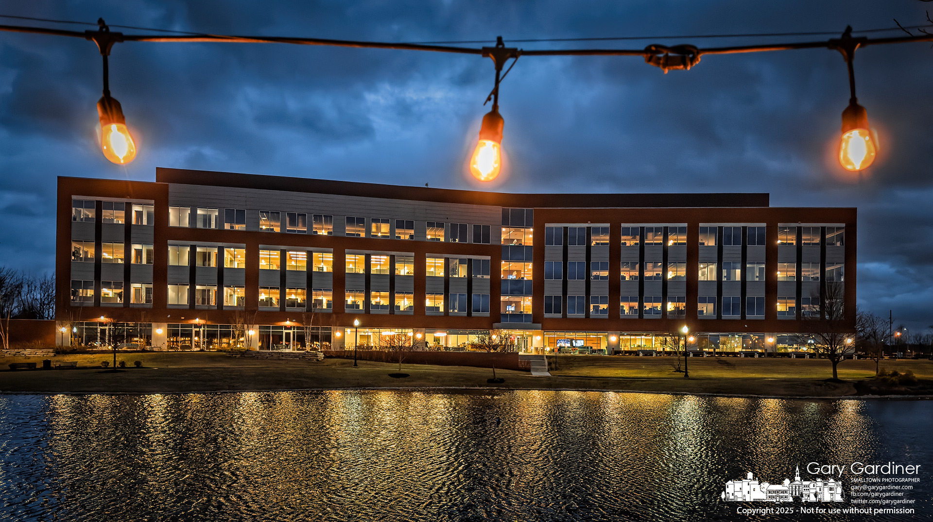 The Renaissance Hotel's patio lights frame the illuminated DHL building, whose lights are reflected in Guitar Lake, which lies between them. My Final Photo for March 20, 2025.