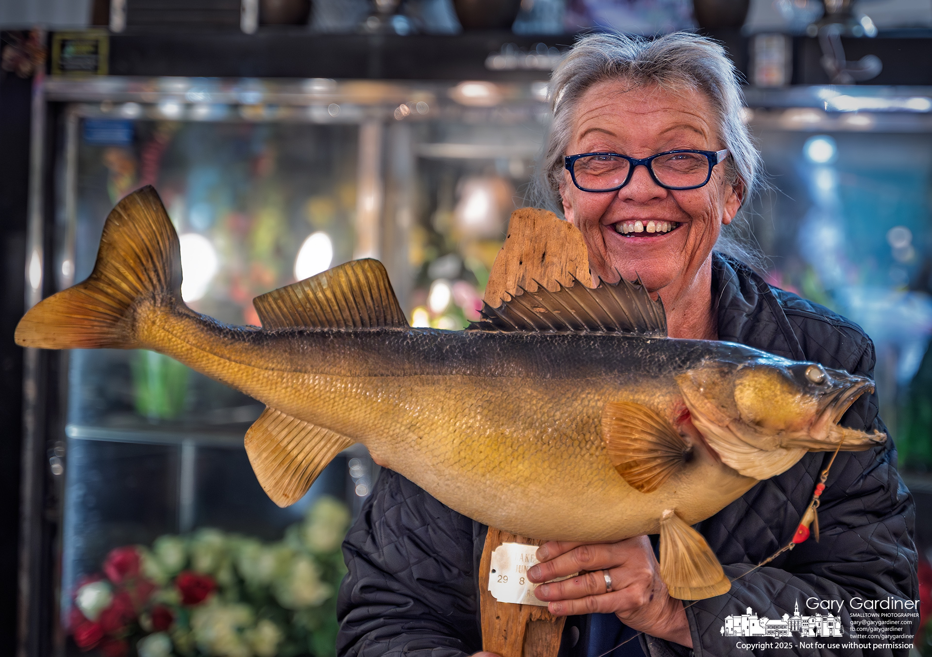 Lorei Rees holds the 22-inch walleye her husband caught and proudly mounted for display in their New Albany home. She brought the fish to Talbott's Florist to have it in a casket spray for his funeral on Tuesday when she plans to place it in his casket. My Final Photo for March 8, 2025.