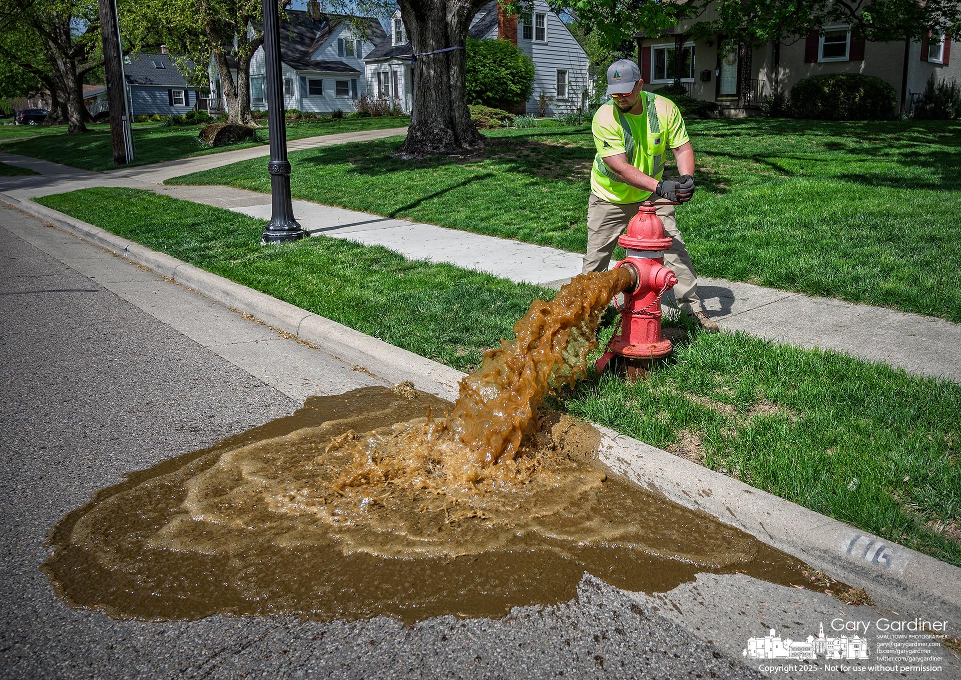 Rusty water pours from a fire hydrant on North West Street as the city begins its annual testing program, checking valves for proper function and ensuring strong water flow. My Final Photo for April 28, 2025.