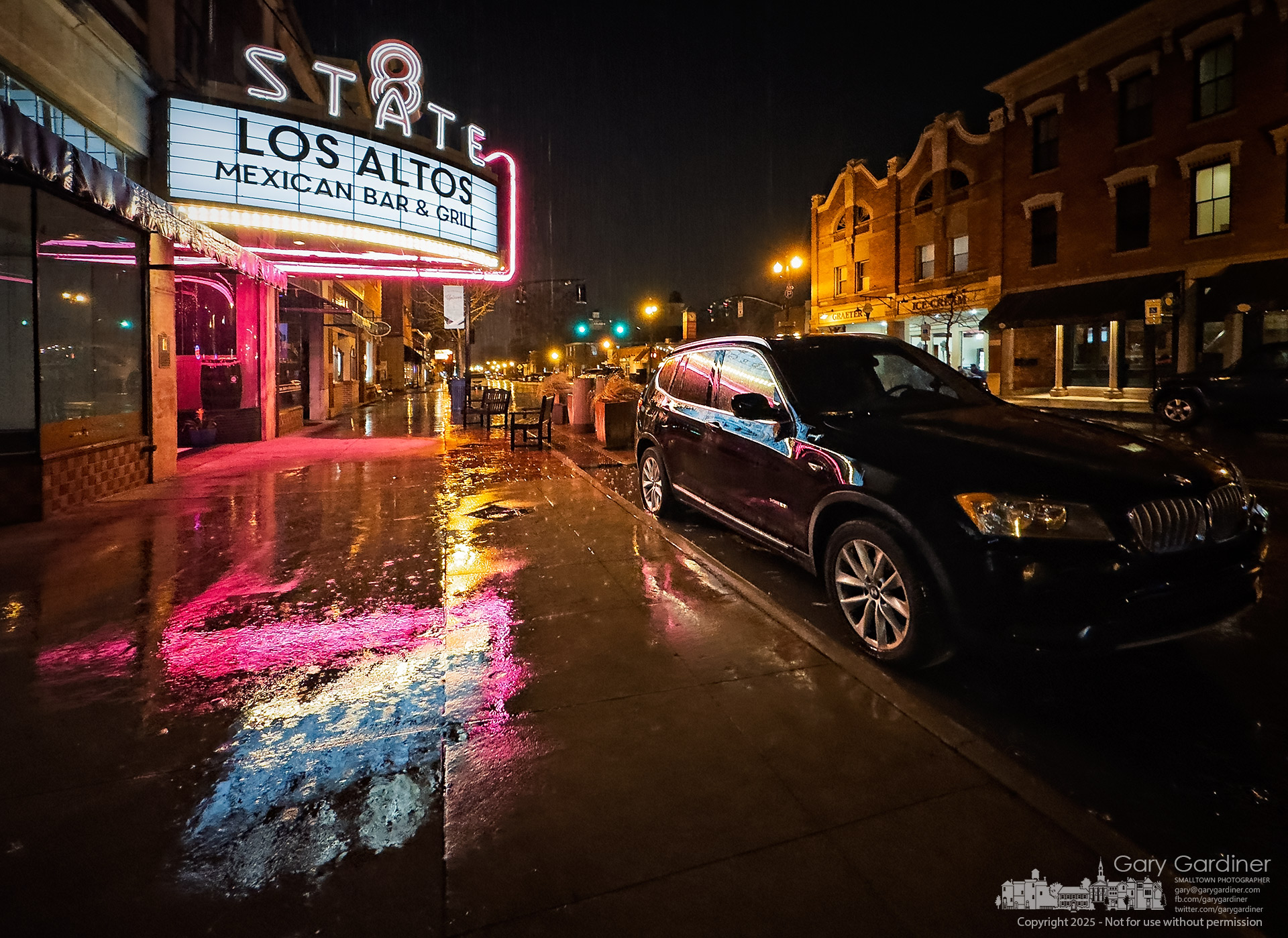 The 8 State marquee reflects its bright lights on glistening surfaces during an early evening rain in Uptown Westerville.