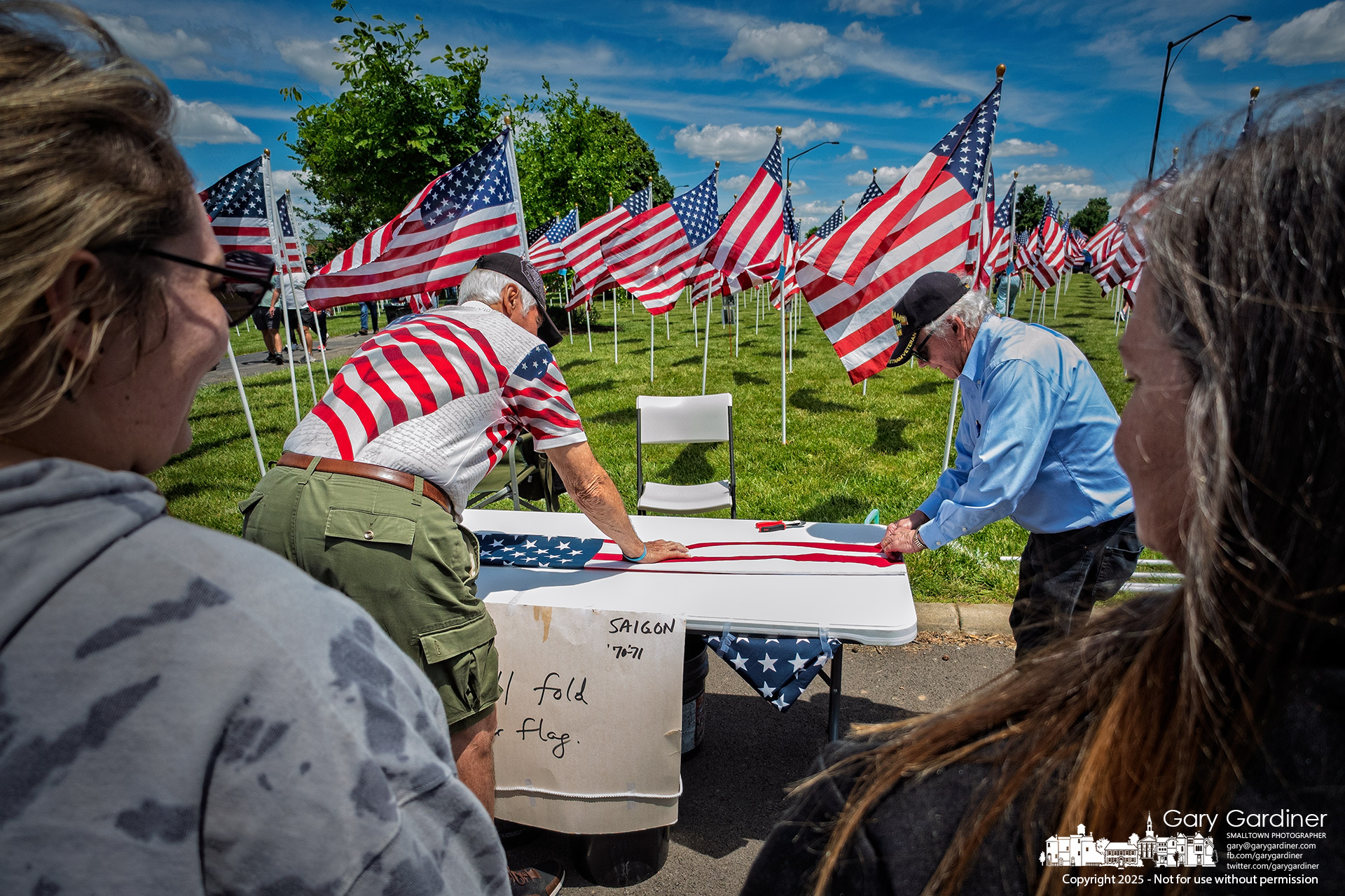 U.S. Army Vietnam veterans fold Field of Heroes flags before presenting them to individuals who purchased them in remembrance of a military member during the Memorial Day weekend event.