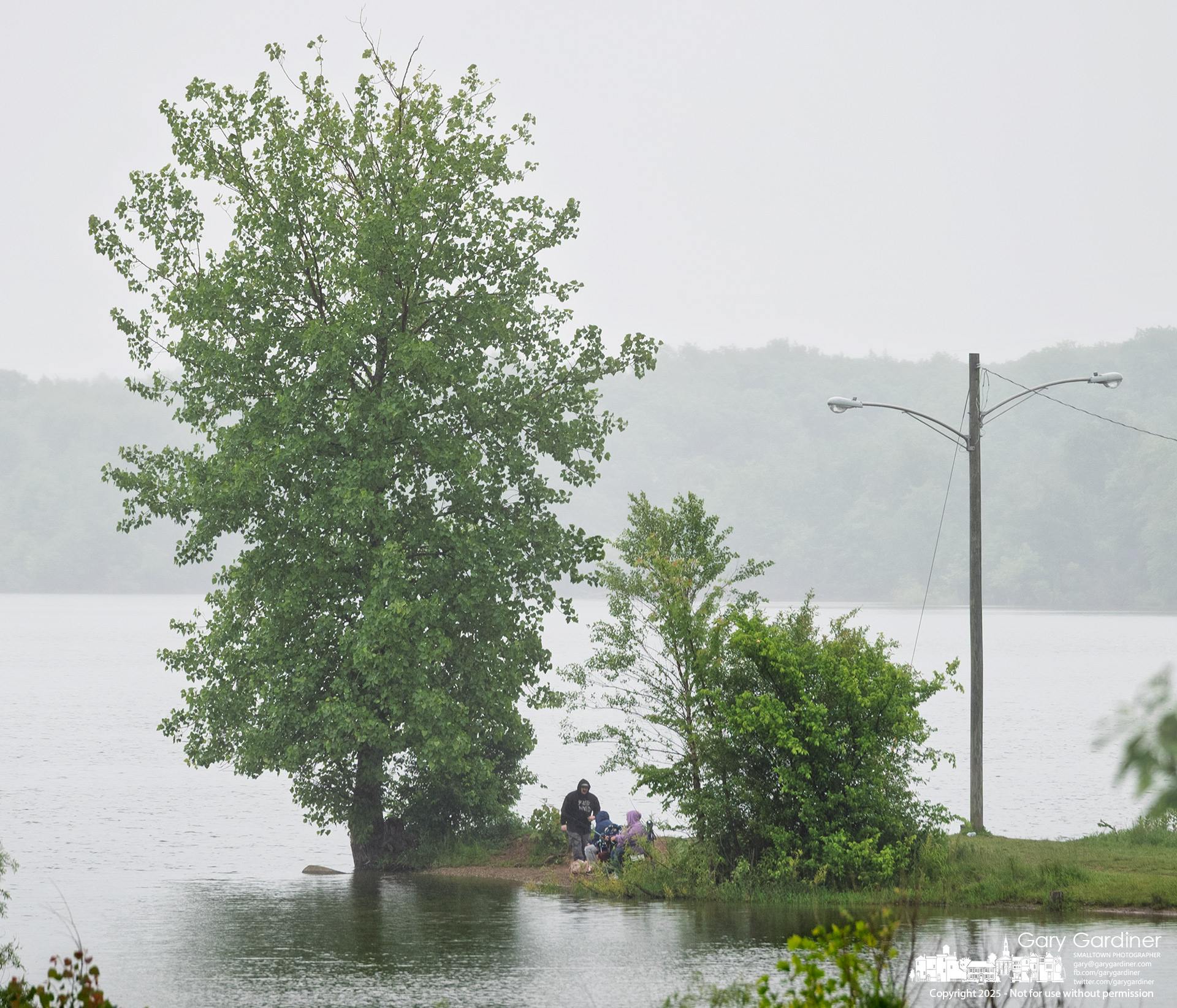 A family casts their lines into the water during a quiet afternoon rain along the shoreline near Hoover Dam. My Final Photo for May 27, 2025.