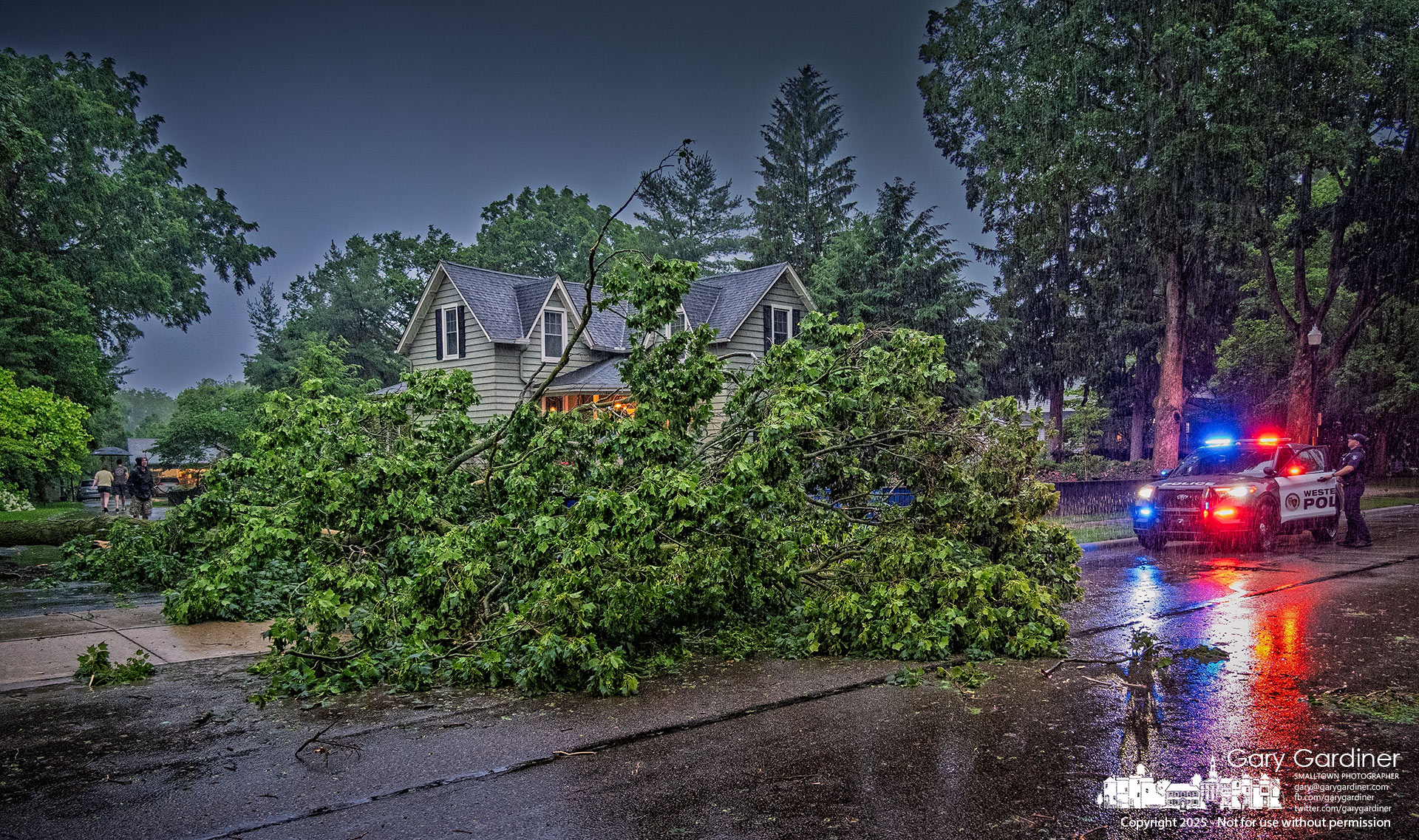 Westerville police direct traffic around a tree that fell into the southbound lane of North West Street early Wednesday as a strong thunderstorm moved across Westerville, knocking down trees and damaging power lines. My Final Photo for June 18, 2025