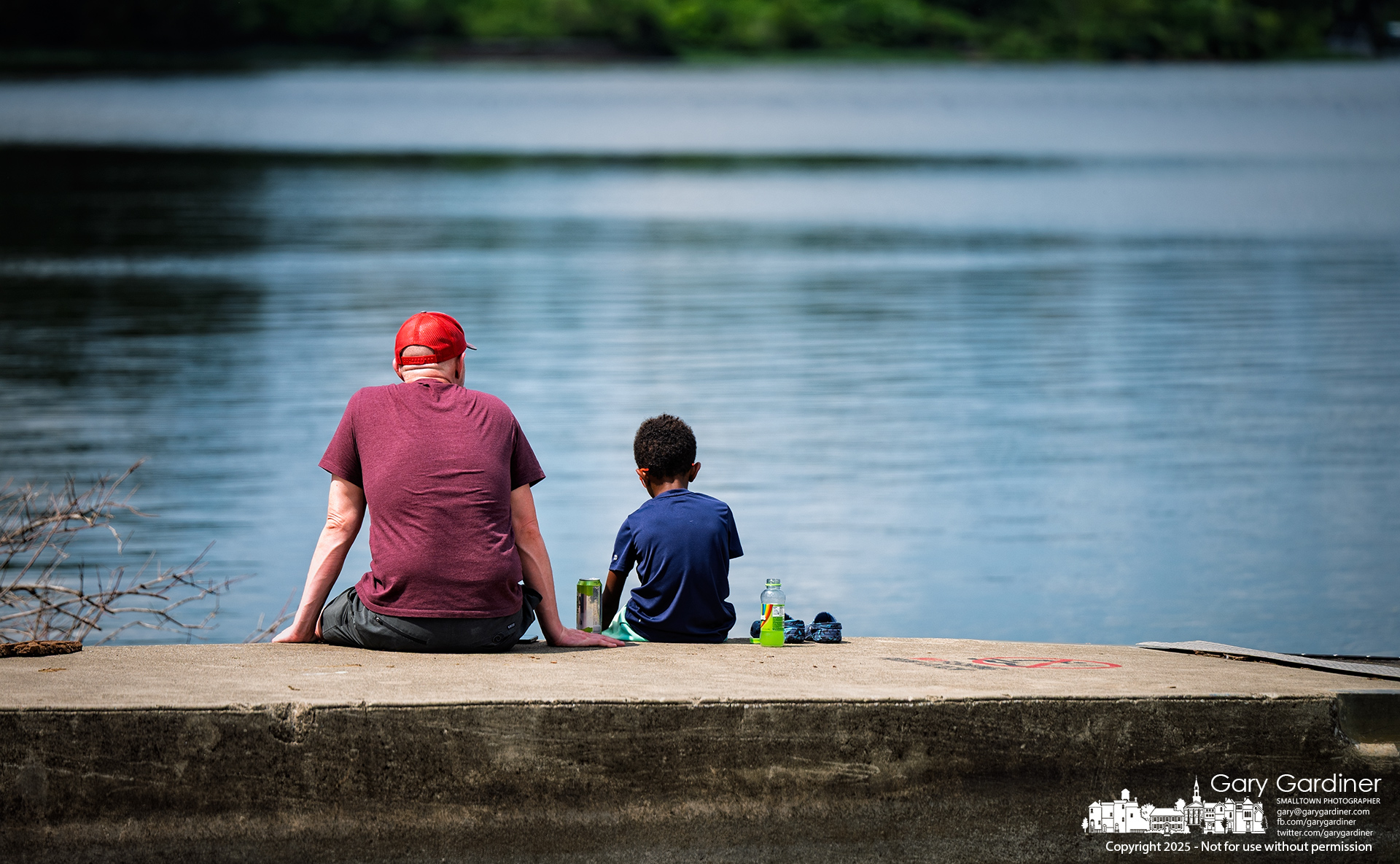 A father and son enjoy snacks while sitting on the dock at Red Bank Marina, the halfway point of their Sunday afternoon bike ride. My Final Photo for July 13, 2025.