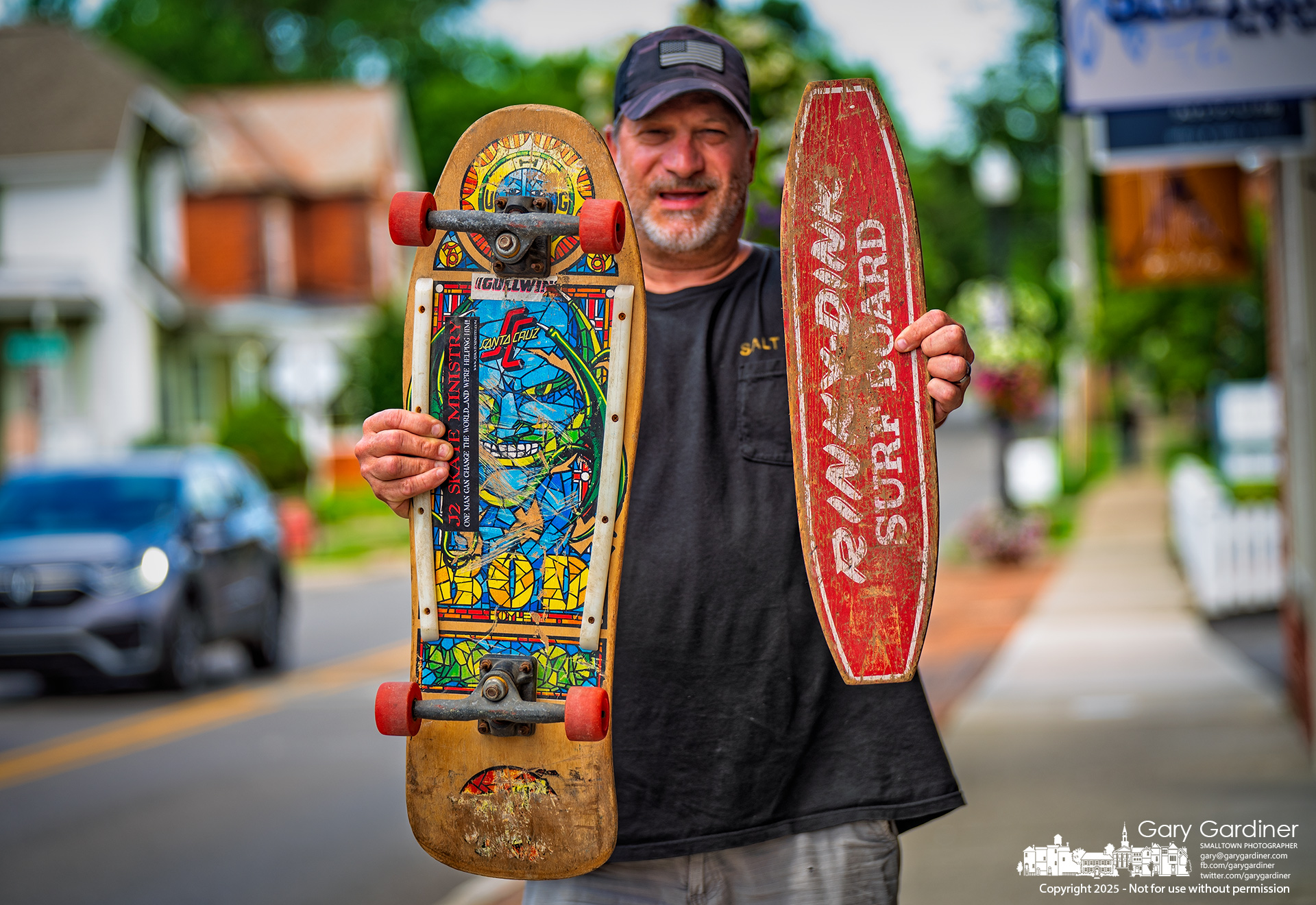 A skateboarder holds two vintage boards outside Old Dkool Skate Shop in Uptown Westerville. The board on the left is a mid 1980's Bob Roskoff board with a Jim Phillips face design. The smaller Pinky-Dink board at right has steel wheels could be from the late 1950s to the early 1960s. My Final Photo for June 2, 2025.