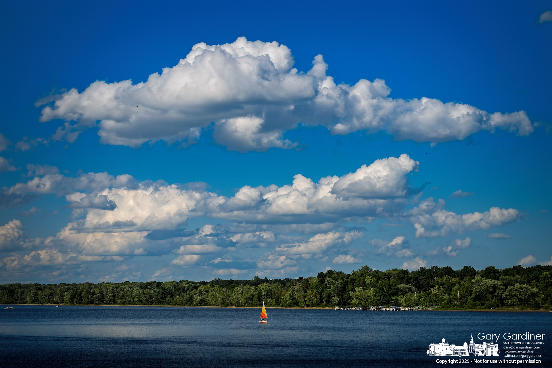A sailboat sails downwind beneath a sky dotted with cumulus clouds over Hoover Reservoir on Sunday afternoon. My Final Photo for August 24, 2025.
