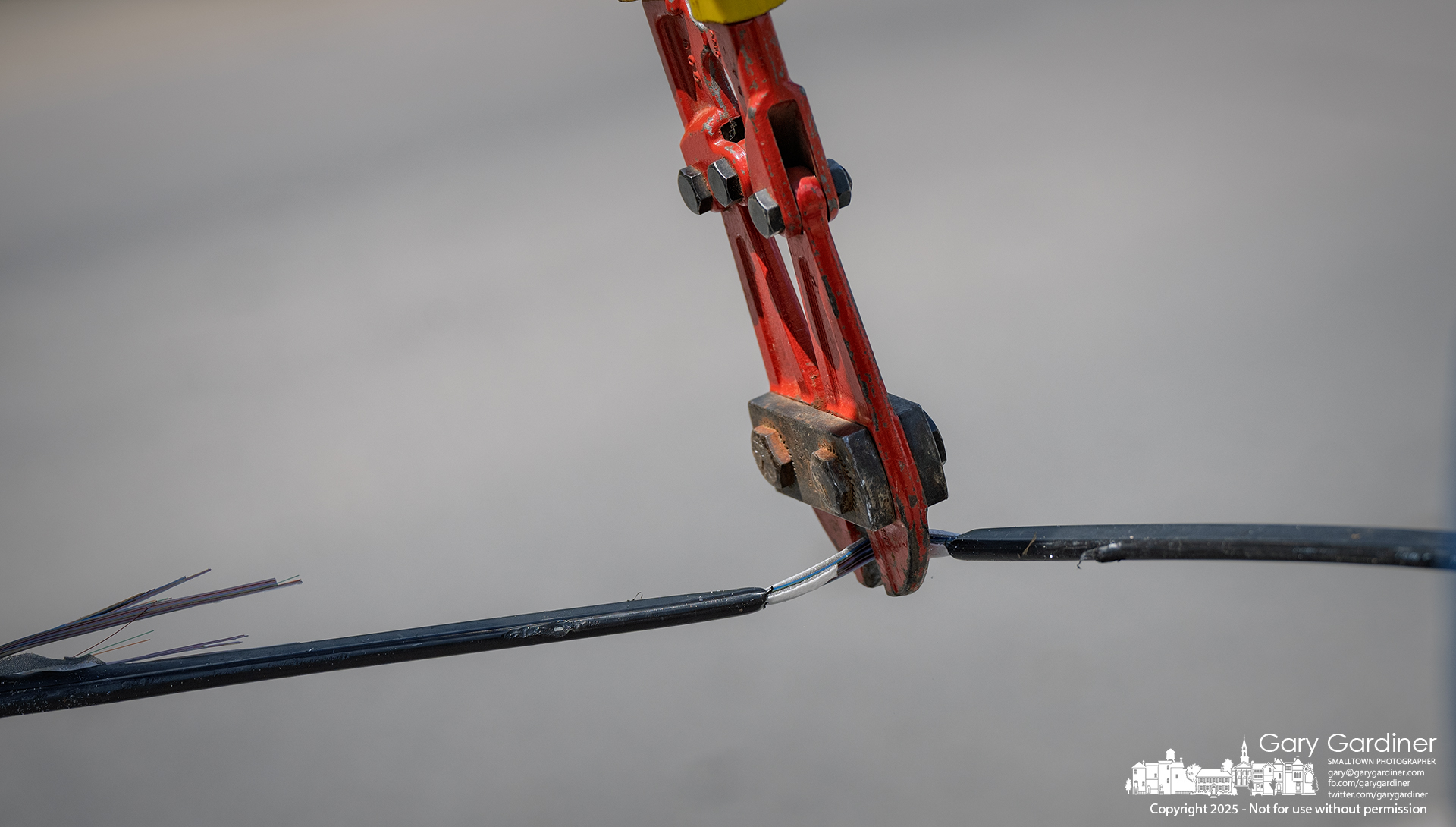 Bolt cutters snip through a section of ATT fiber optic cable that fell across Sunbury Road when a semi-truck dragged the low-hanging cable to the ground. My Final Photo for August 18, 2025.