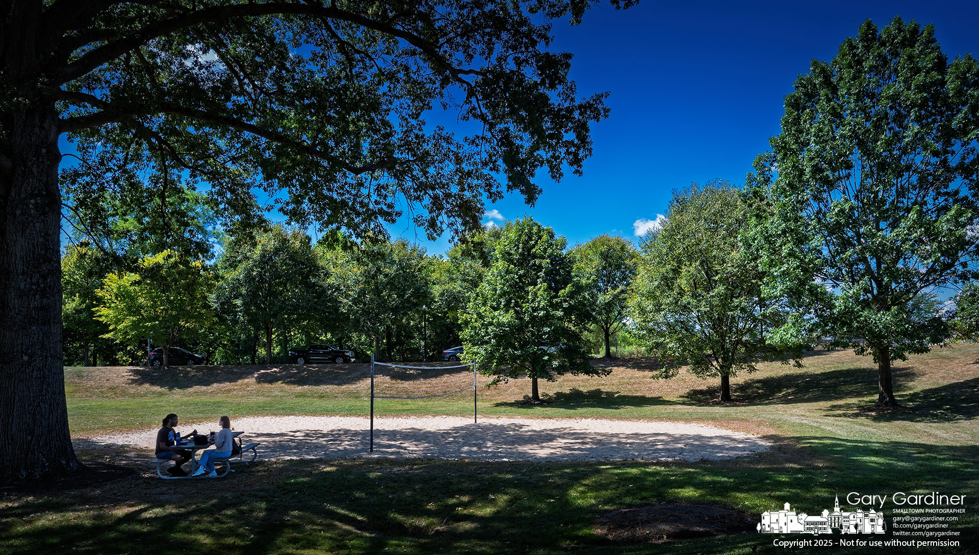 Two lunchgoers enjoy the shade of one of Alum Creek North’s largest oak trees, making their meal a bit more pleasant. My Final Photo for September 3, 2025.