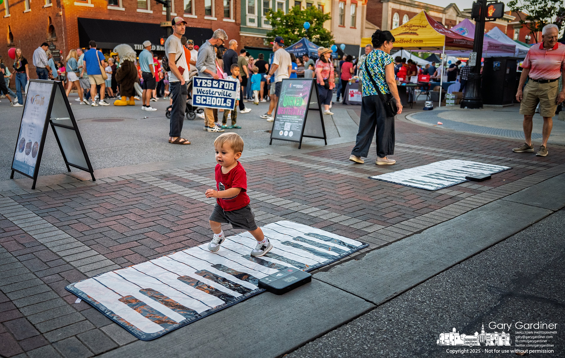 A young child joyfully dashes across a giant floor piano during Fourth Friday in Uptown Westerville. My Final Photo for September 26, 2025.