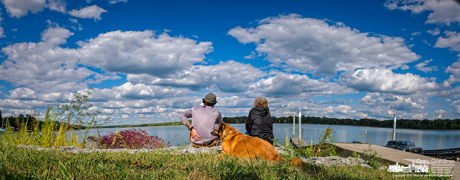 The family dog sits alongside his owners as they enjoy the cool autumn breeze and vibrant clouds drifting over Hoover Reservoir. My Final Photo for September 7, 2025.