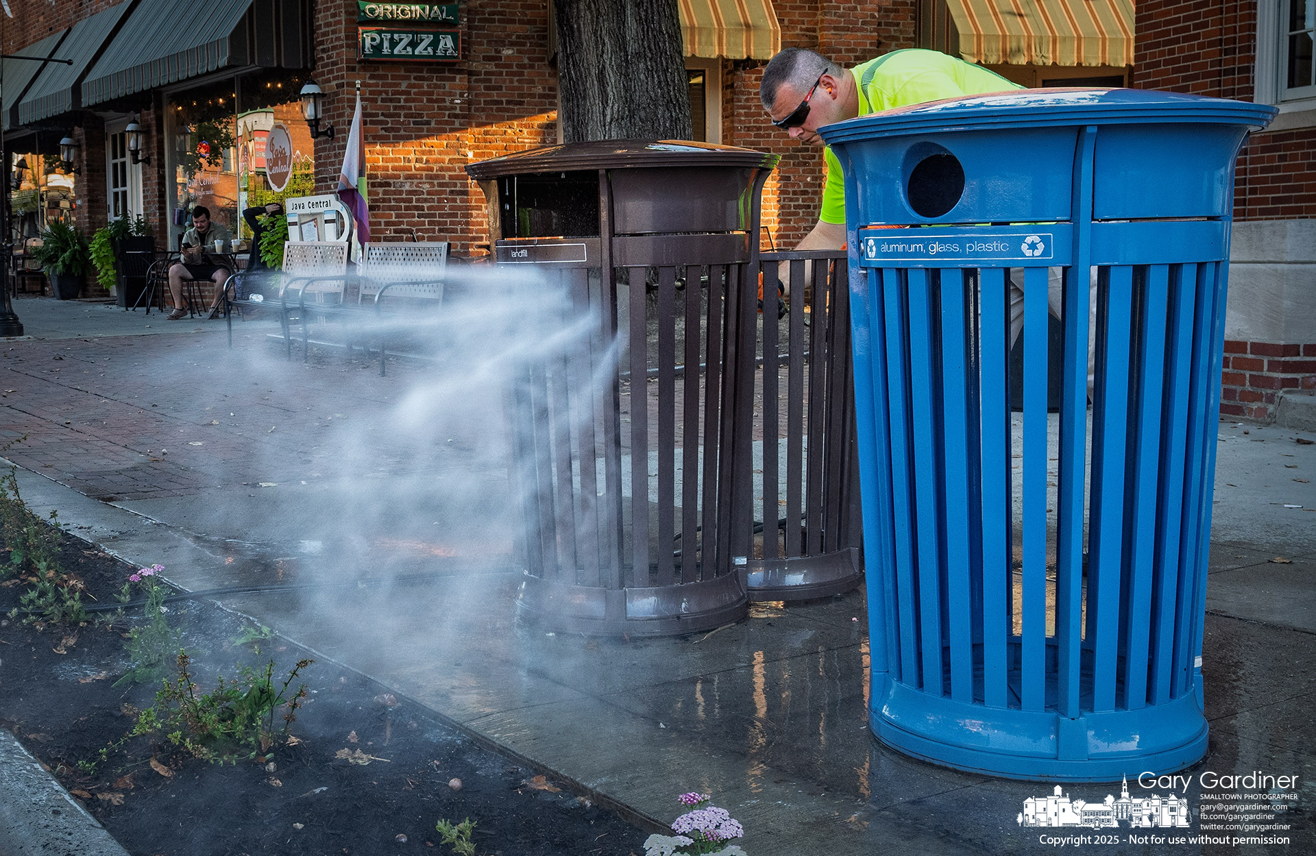 A city service worker power-washes a set of trash and recycling bins Monday morning during the city's fall cleanup effort. My Final Photo for September 29, 2025.