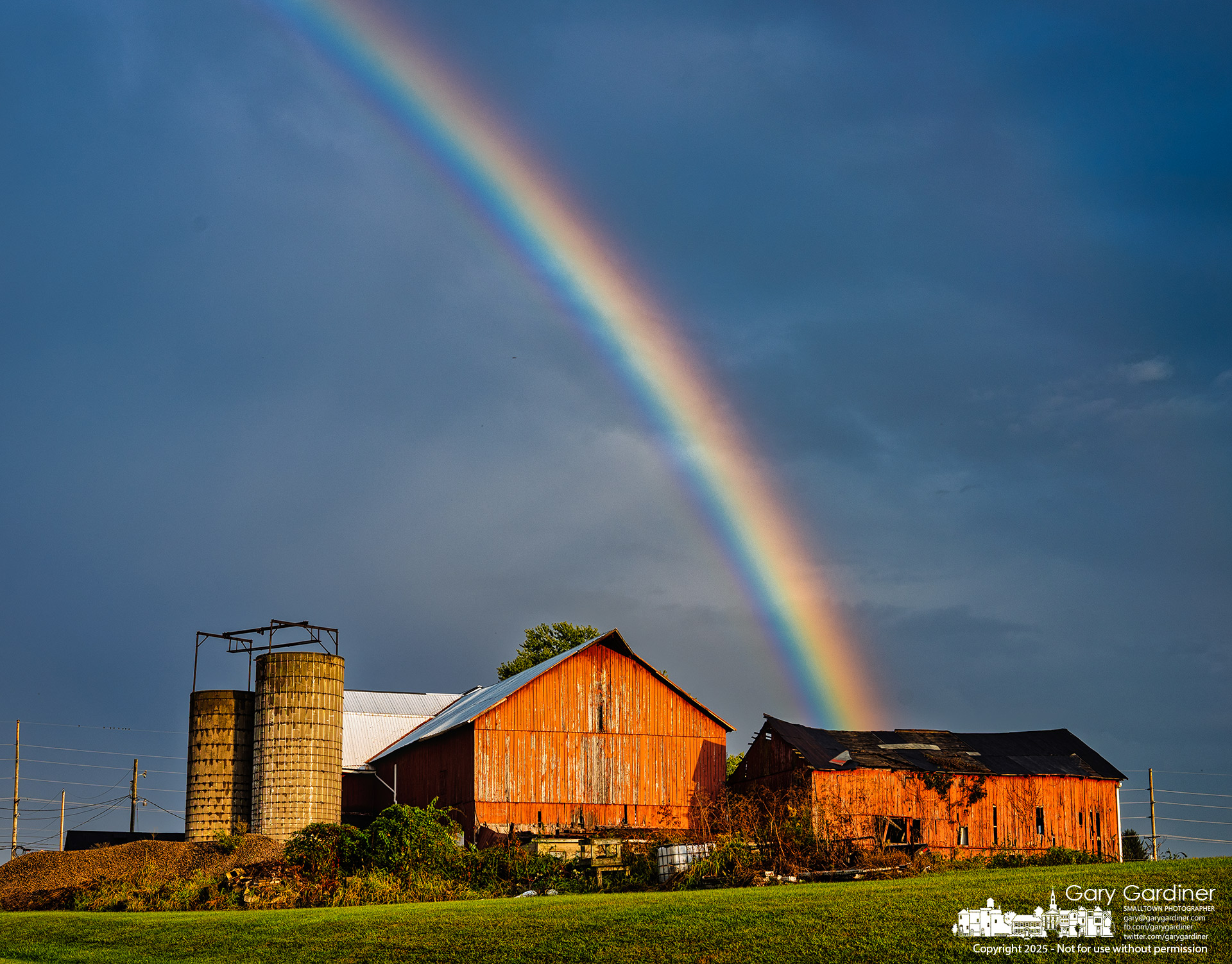 A rainbow appears to land behind the barns at Yarnell Farm on Africa Road after a passing storm. My Final Photo for September 25, 2025.