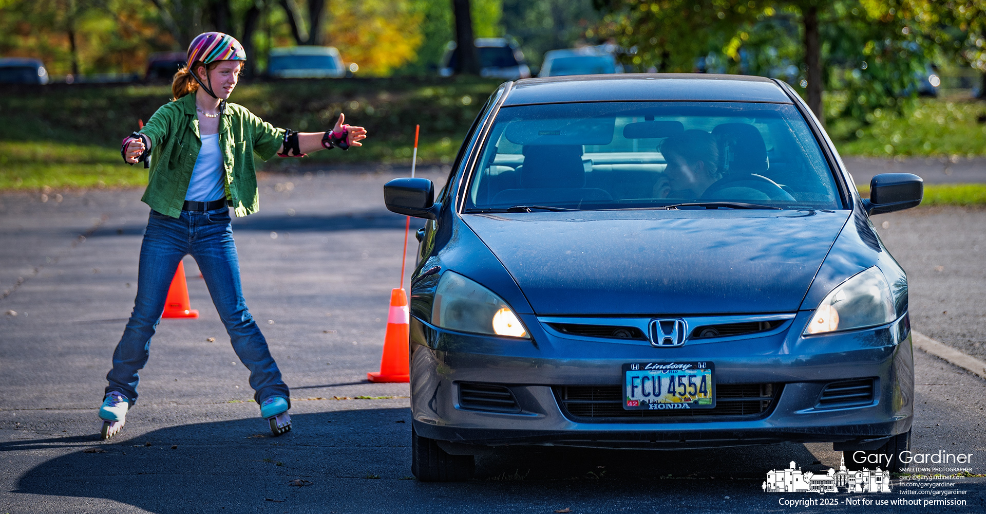 A driver practicing her maneuverability skills gets help from a friend on inline skates, guiding her through the obstacle course they set up in the Highlands Park parking lot. My Final Photo for September 28, 2025.