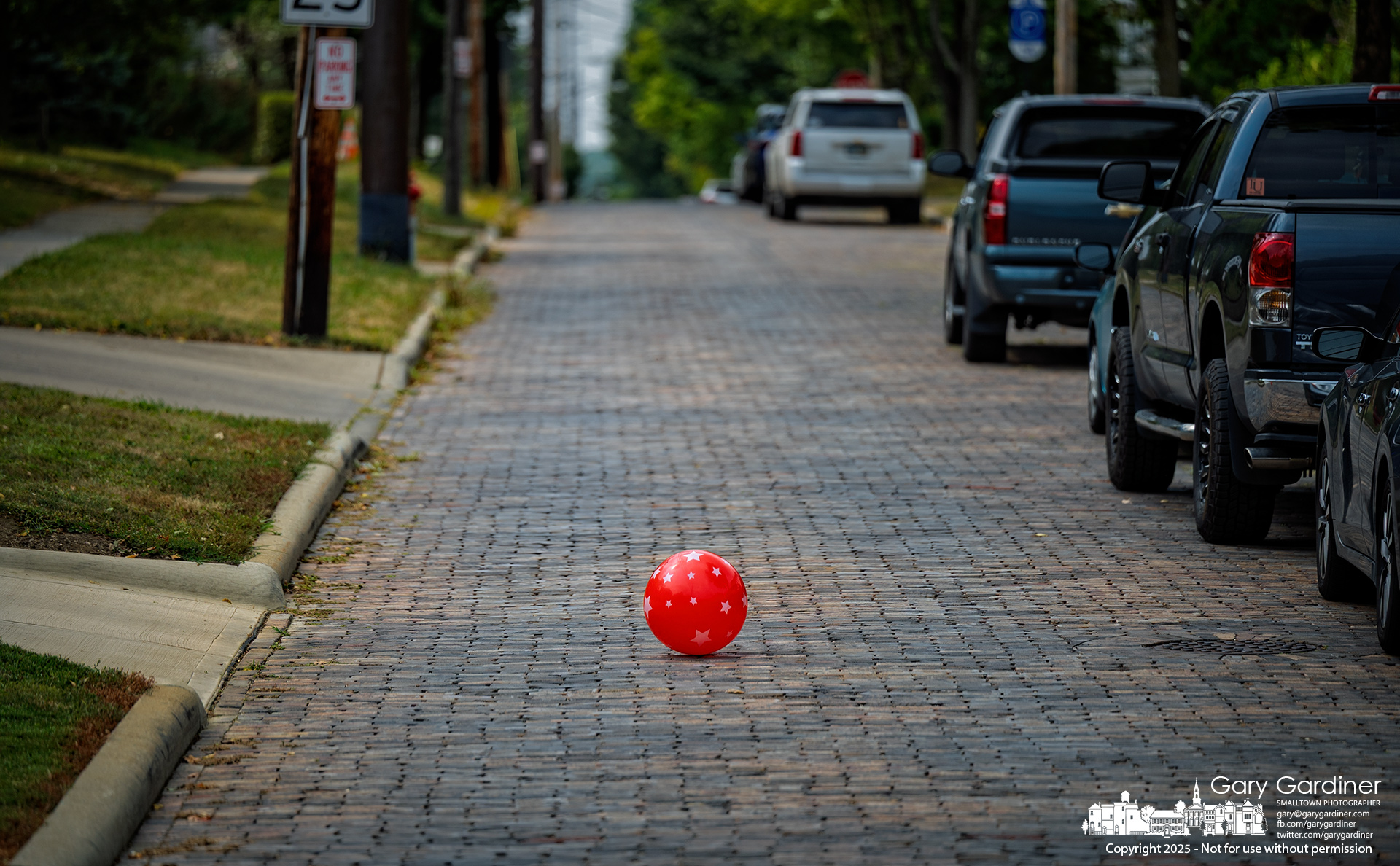 A child’s red play ball rolls and bounces along West Park Street, as if searching for a place to rest for the night. My Final Photo for September 5, 2025.