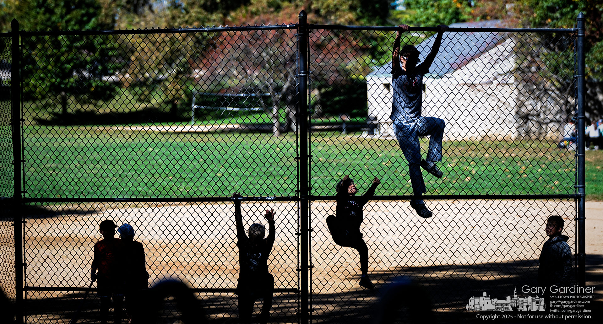 A pickup baseball player climbs the backstop to celebrate a pretend home run he hit during a game with friends at Alum Creek Park. My Final Photo for October 16, 2025.