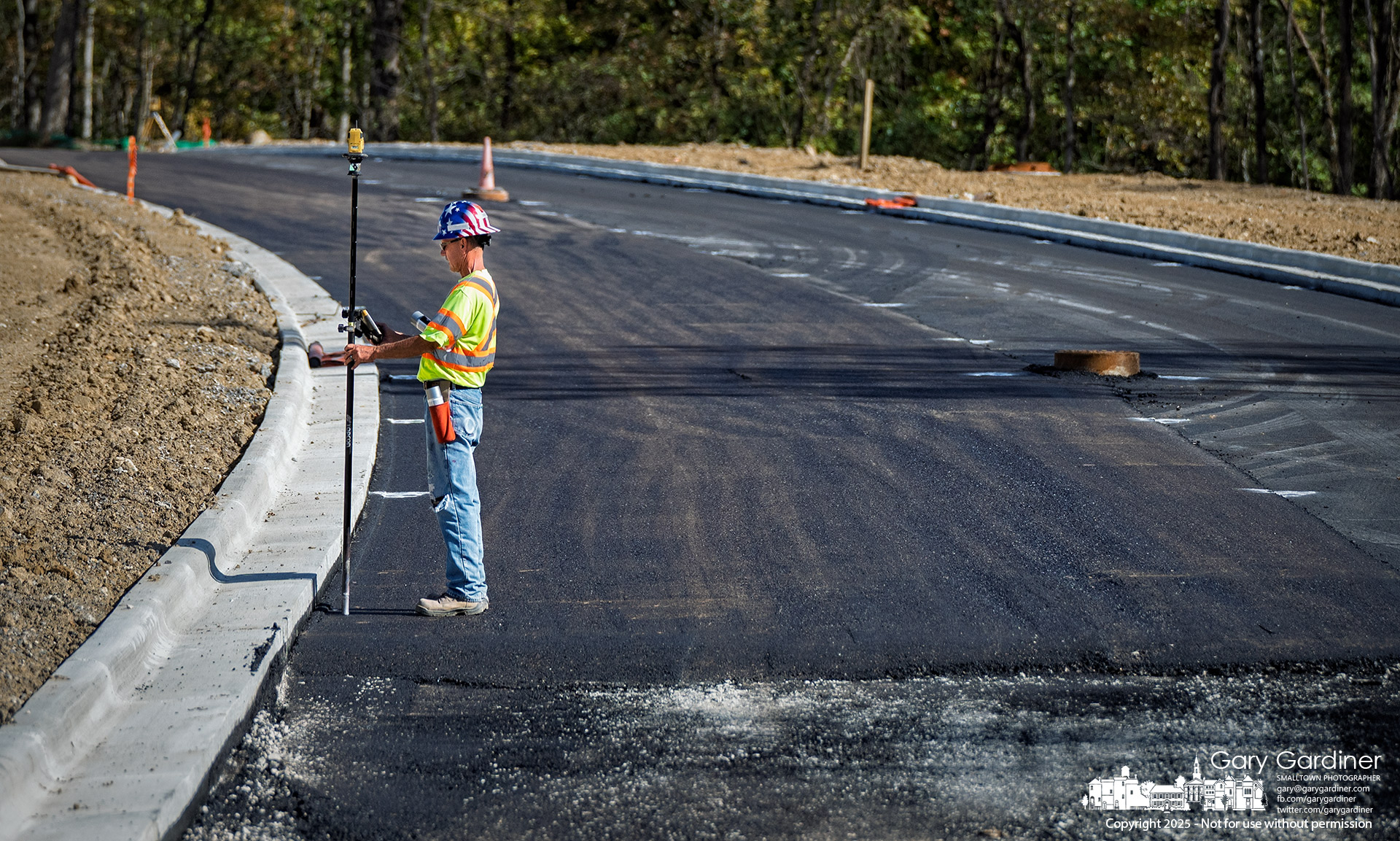 A worker uses a GPS device to check the elevation of asphalt paving installed Monday on one of the roads through the East of Africa project. My Final Photo for October 13, 2025.