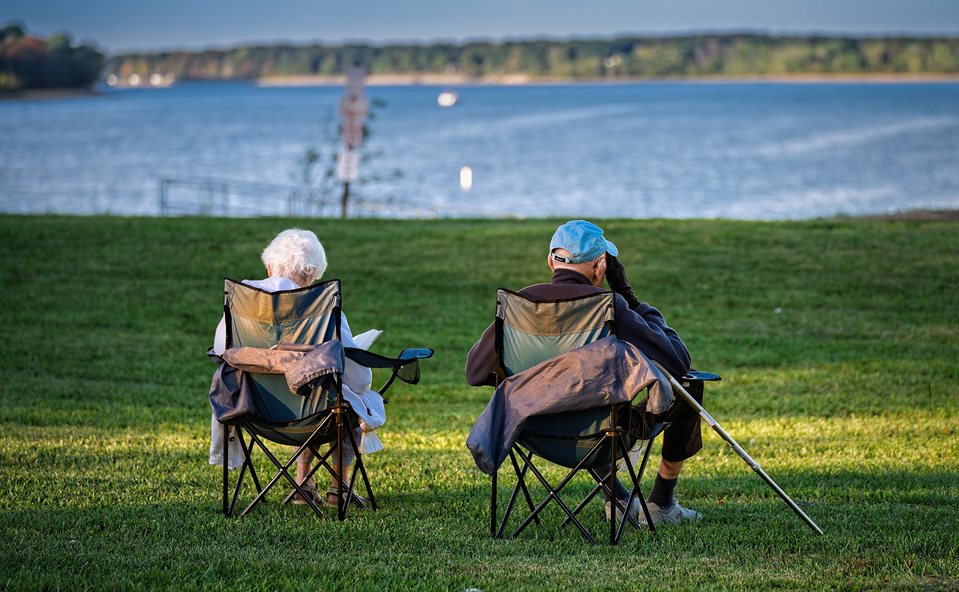 A couple relaxes in folding chairs overlooking the Red Bank Park area of Hoover Reservoir, enjoying the sunset before heading to dinner. My Final Photo for October 1, 2025.