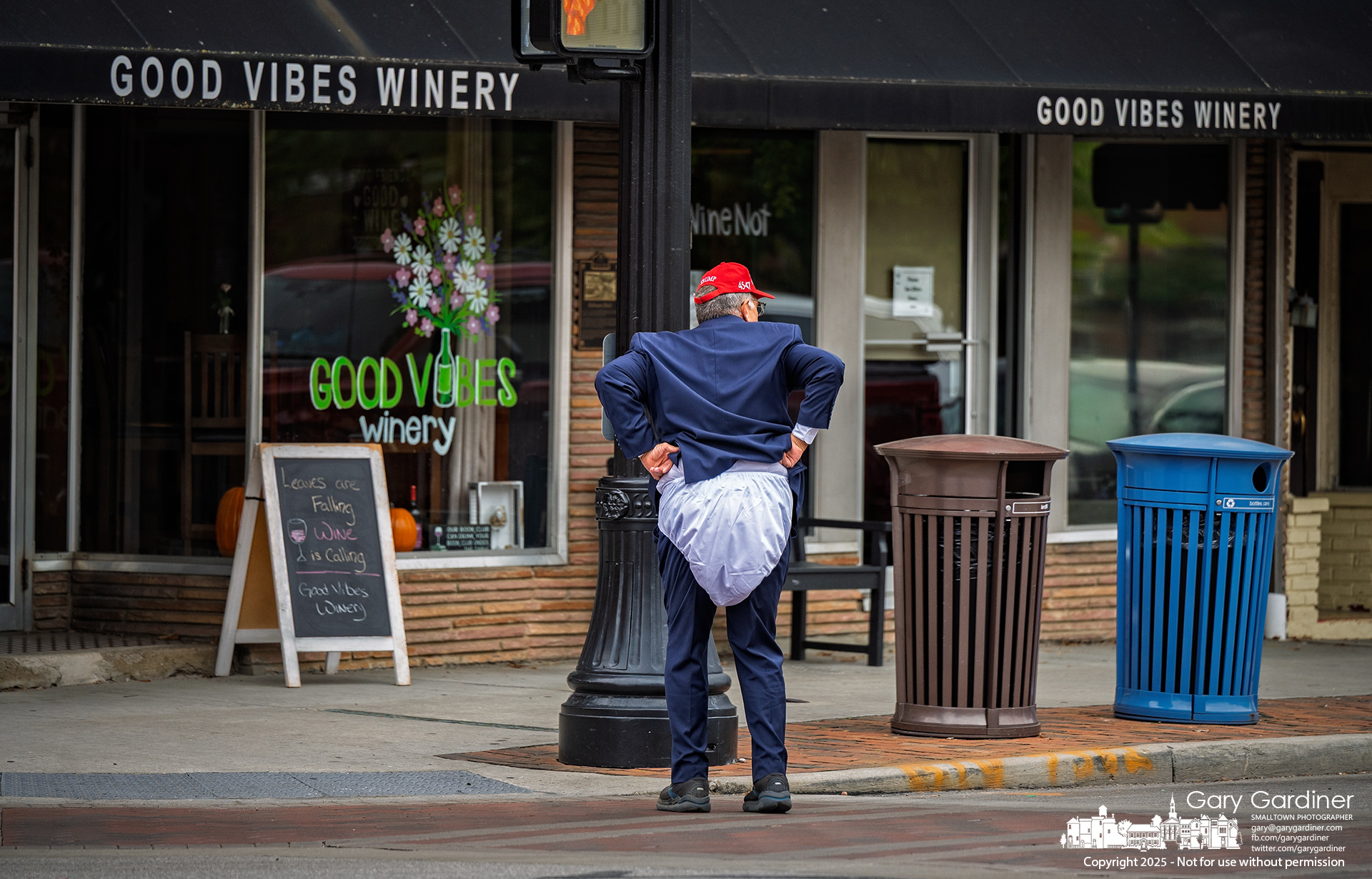 A political satirist dressed in a MAGA hat and oversized diaper performed for nearly two hours at the corner of State and College, taunting passersby with exaggerated displays of bravado and reacting theatrically to their responses. My Final Photo for October 15, 2025.