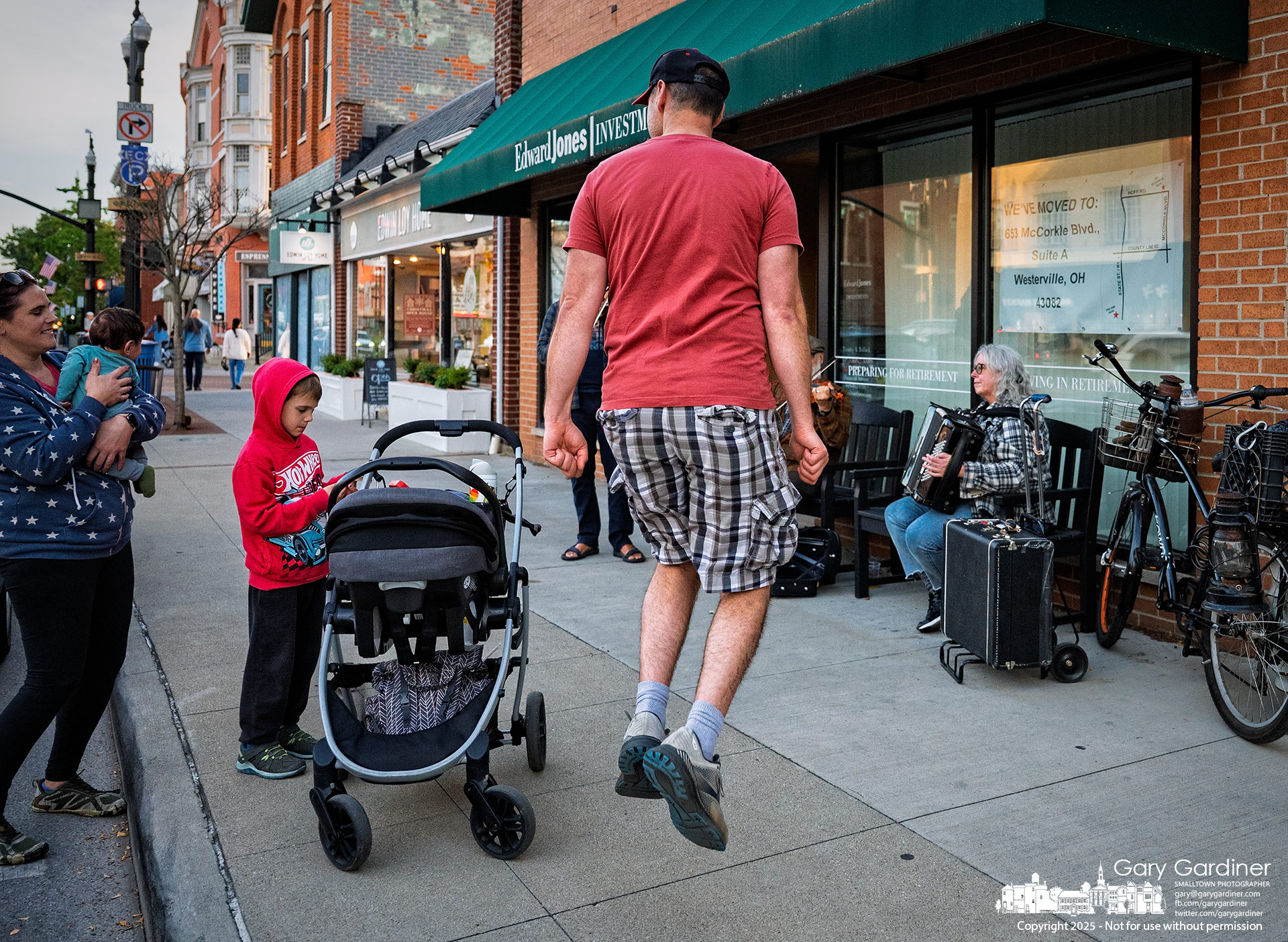 A father dances an Irish jig to the sound of street musicians in Uptown Westerville, delighting his wife and embarrassing his son.