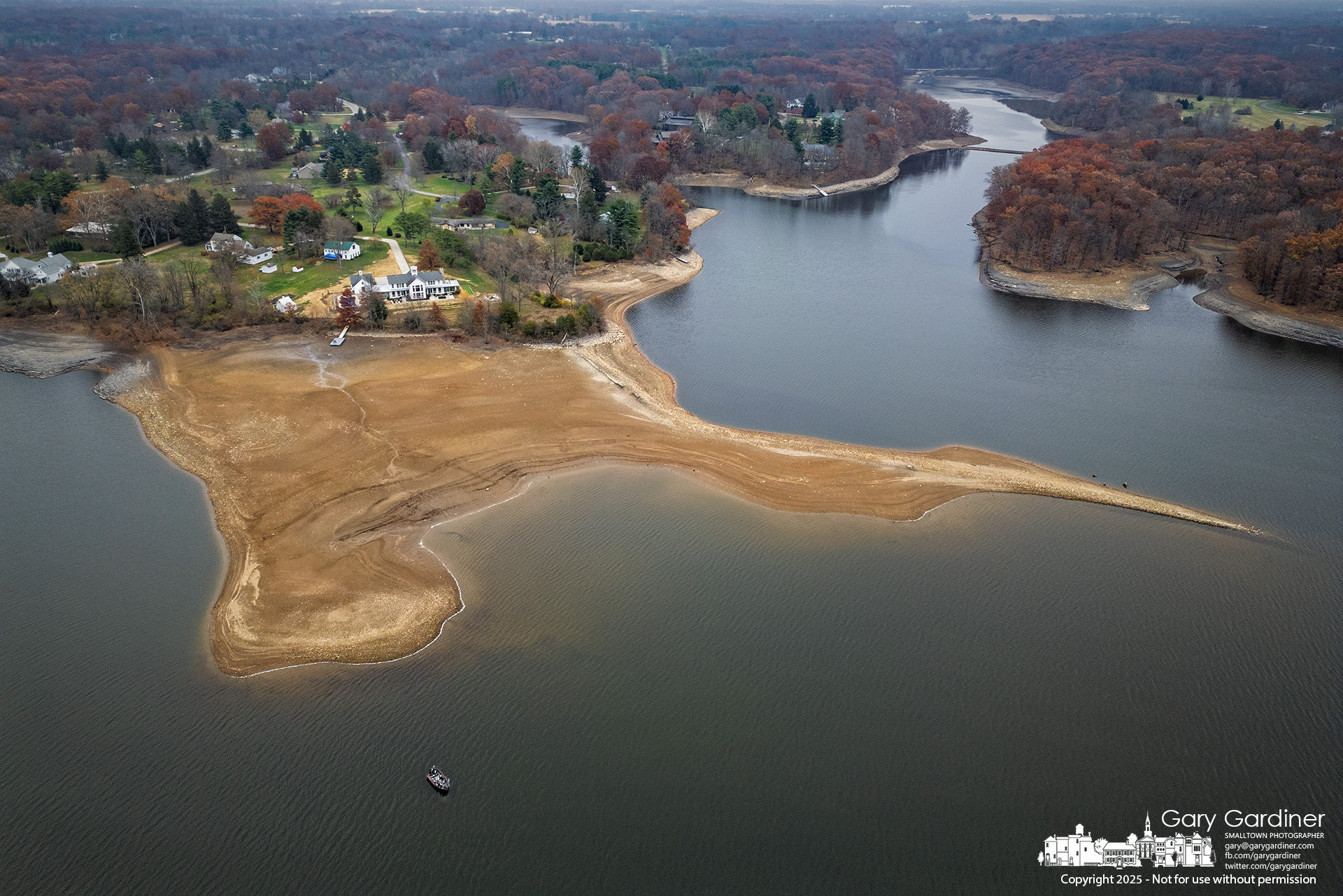 Low water levels at Hoover Reservoir, temporarily reduced for dock and boat landing maintenance, expose the shoreline as a lone fishing boat drifts along the newly revealed banks. My Final Photo for November 20, 2025.