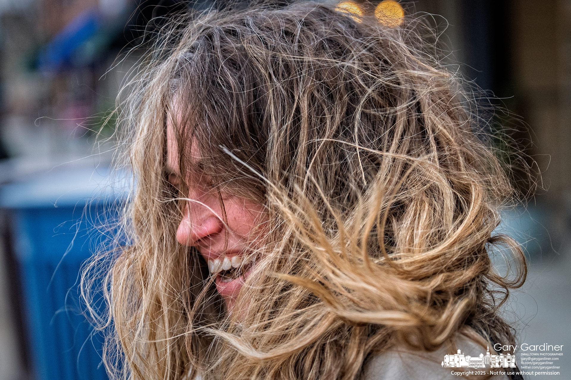 An Uptown shopper has her hair blown into her face as a cold front moves through Ohio, bringing lower temperatures and strong winds. My Final Photo for November 26, 2025.