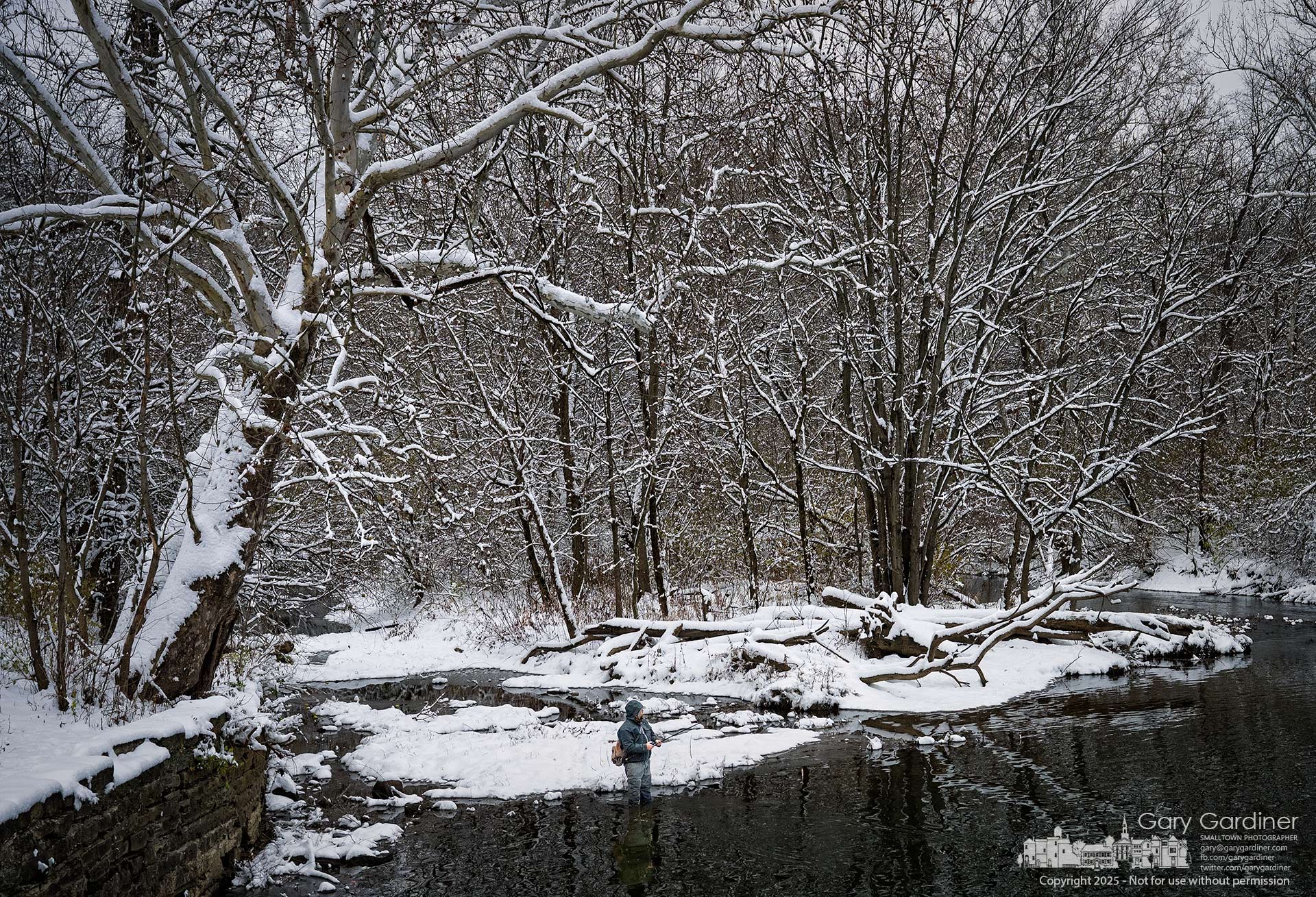 A lone fisherman stands below the Alum Creek North Dam as fresh snow gathers on the trees and quiets the creek around him. My Final Photo for December 2, 2025.