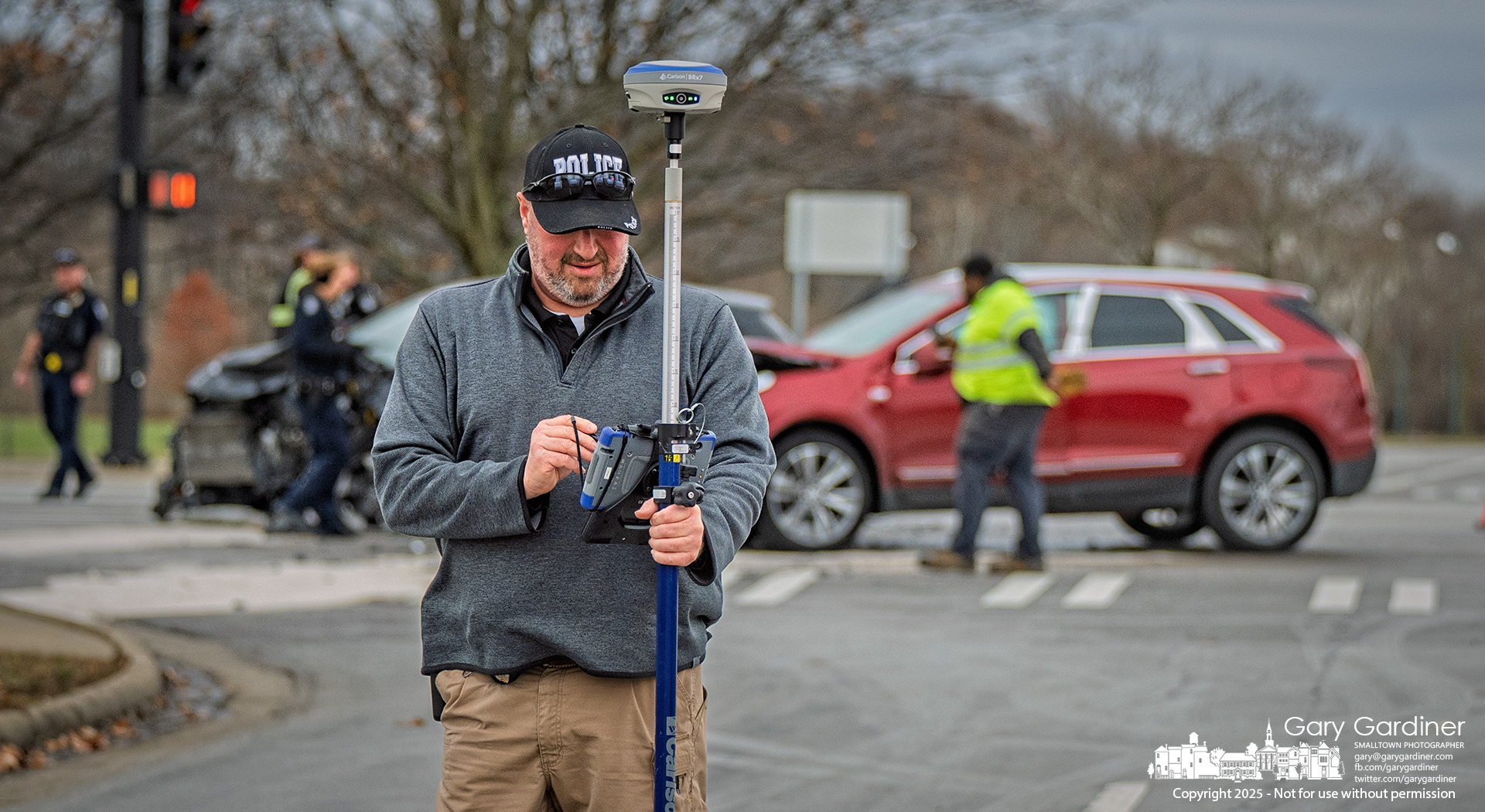 A Westerville police investigator uses a GPS device to map the scene of a serious car crash Thursday afternoon at Cleveland Avenue and County Line Road. My Final Photo for December 18, 2025.