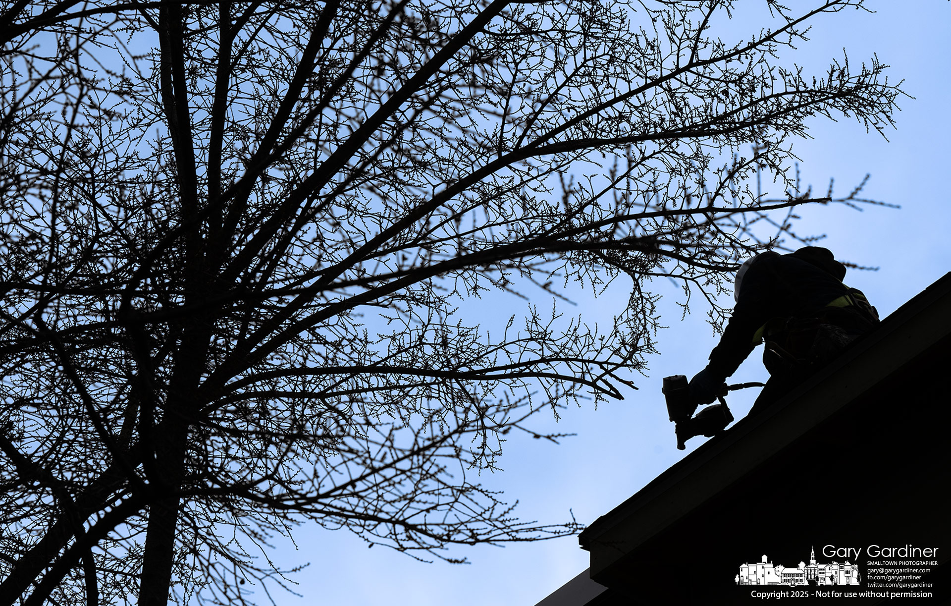 A roofer installs flashing along the walkway roof connecting the old police station to City Hall. My Final Photo for December 1, 2025.