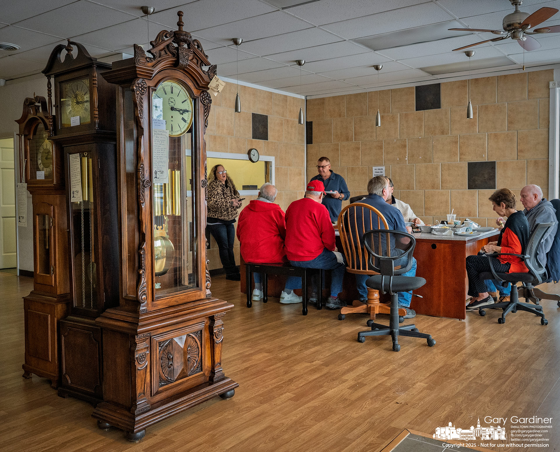 With the showroom nearly cleared, the owners of the Grandfather Clock Company and their families sit down for a catered meal on the business’s final day.