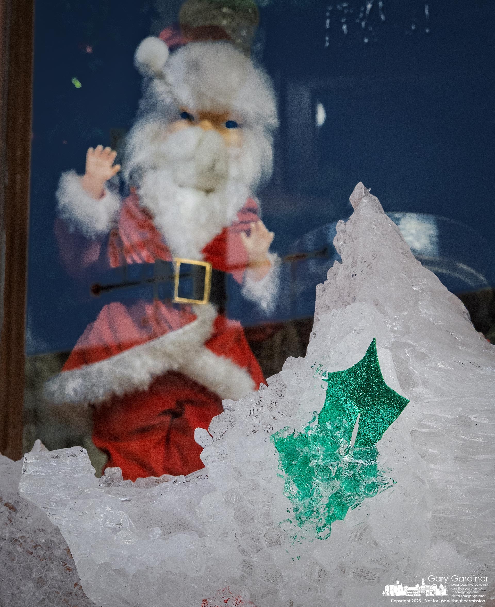 The stuffed Santa in the front window of Westerville Antiques looks confused by the melting and crumbling ice sculpture with a holly leaf just outside his window on the sidewalk. My Final Photo for December 22, 2025.