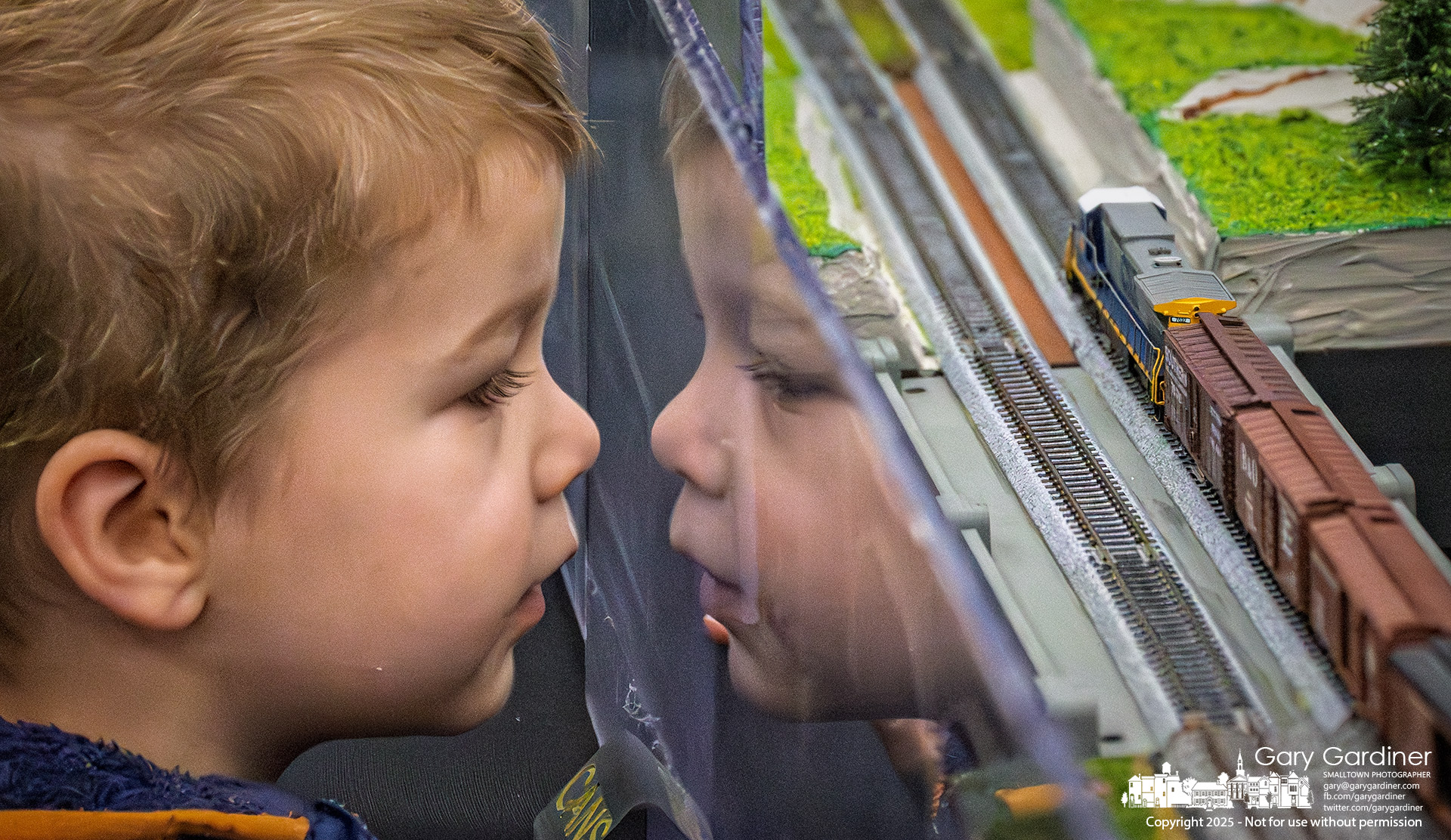 A three-year-old studies the movement of an N-gauge train on dislay at the Westerville Public Library. My Final Photo for December 8, 2025.