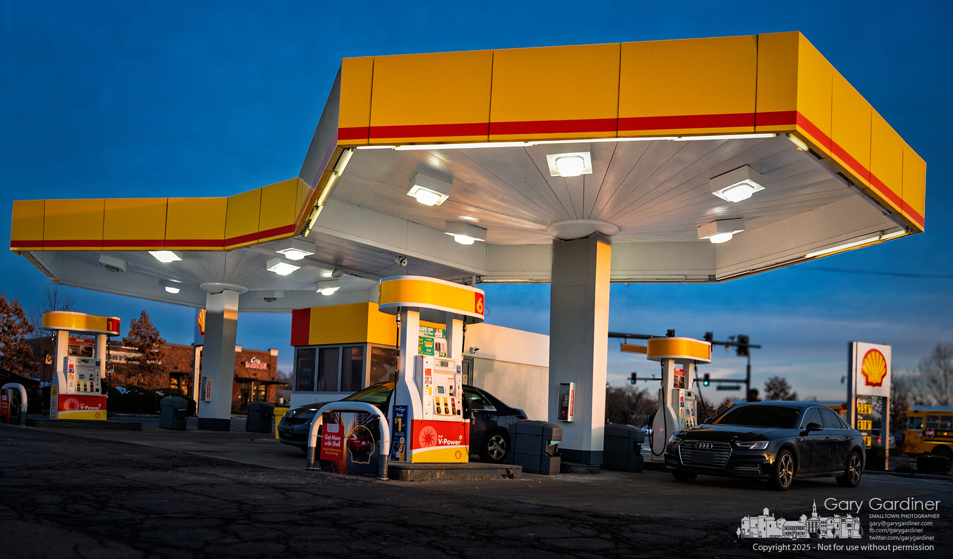 The Shell station at State and Schrock sits in warm sunset light as drivers stop to fill up and move on with the evening rush. My Final Photo for December 9, 2025.