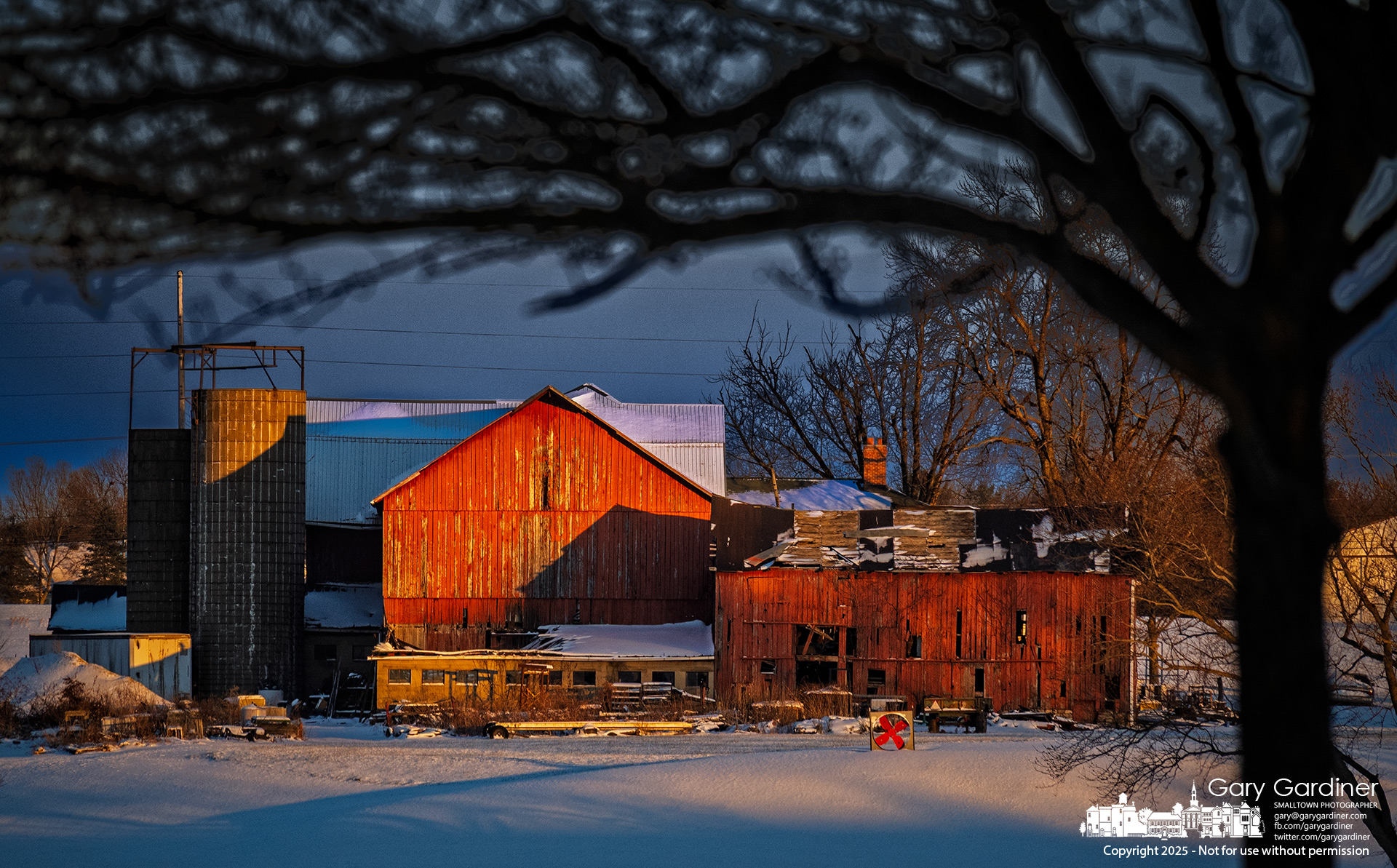 The setting sun casts a deceptively warm glow on the Yarnell Farm barns as temperatures linger in the low teens following a snowstorm. My Final Photo for December 14, 2025.