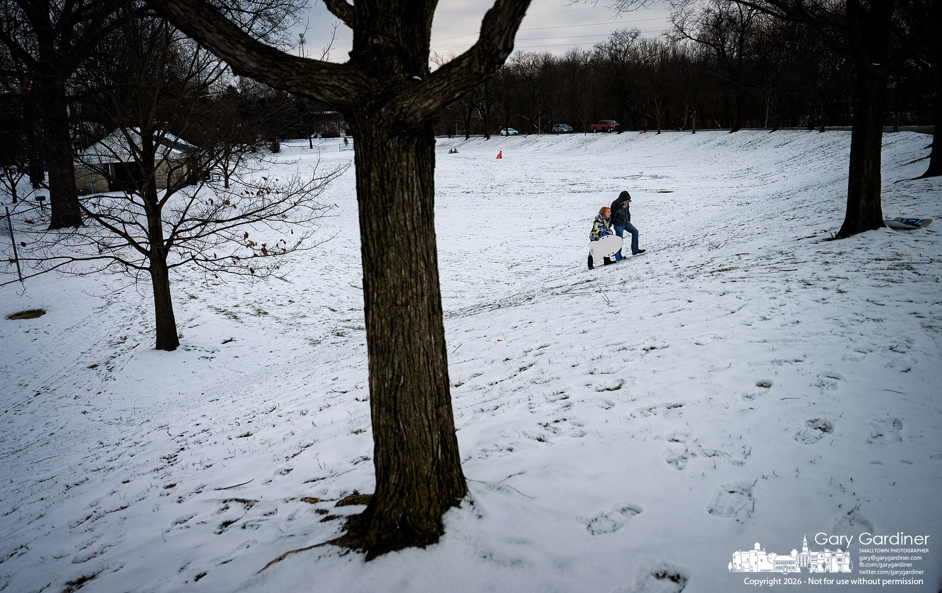 Father and daughter share one last climb up the hill at Alum Creek Park North, ending a snowy afternoon together. My Final Photo for January 1, 2026.