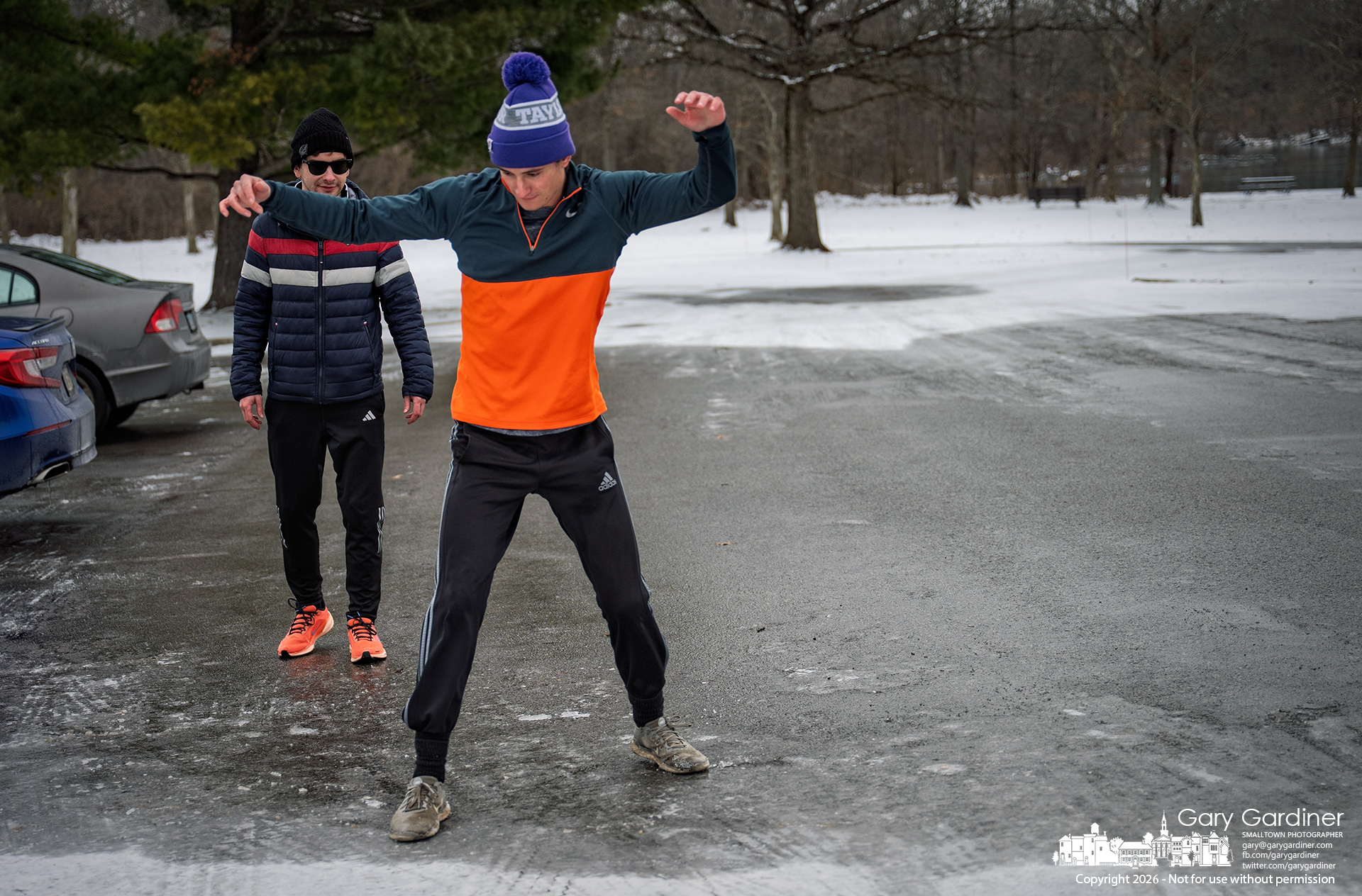 A runner slides across an icy parking lot at Sharon Woods Park while waiting with friends for others to arrive for an afternoon workout. My Final Photo for January 3, 2026.