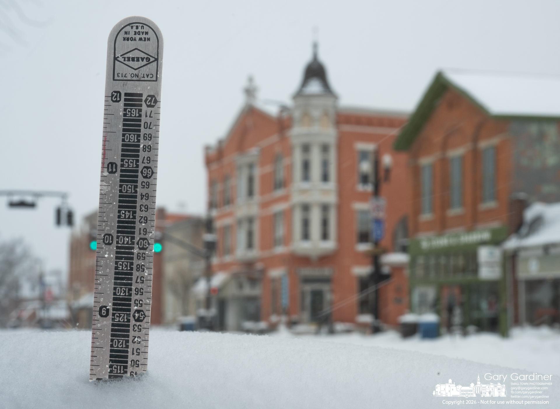 A ruler shows eight inches of snowfall on a sidewalk table in front of Whit's in Uptown on Sunday afternoon. (My Final Photo for January 25, 2026)