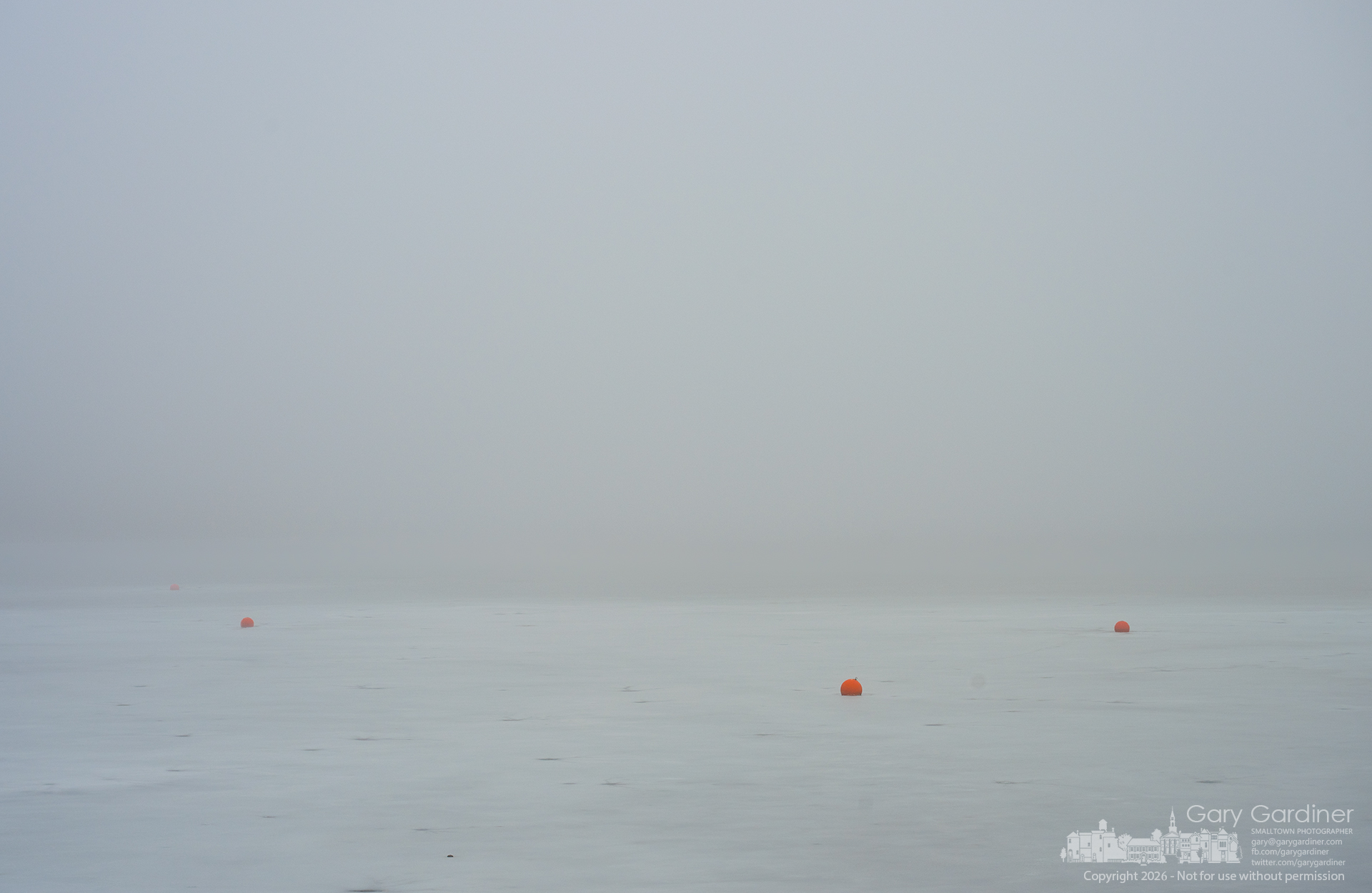 A heavy fog swallows Hoover Reservoir at Red Bank Marina, leaving only a few ice-locked orange buoys to mark where floating docks will return in warmer days. (My Final Photo for February 16, 2026)