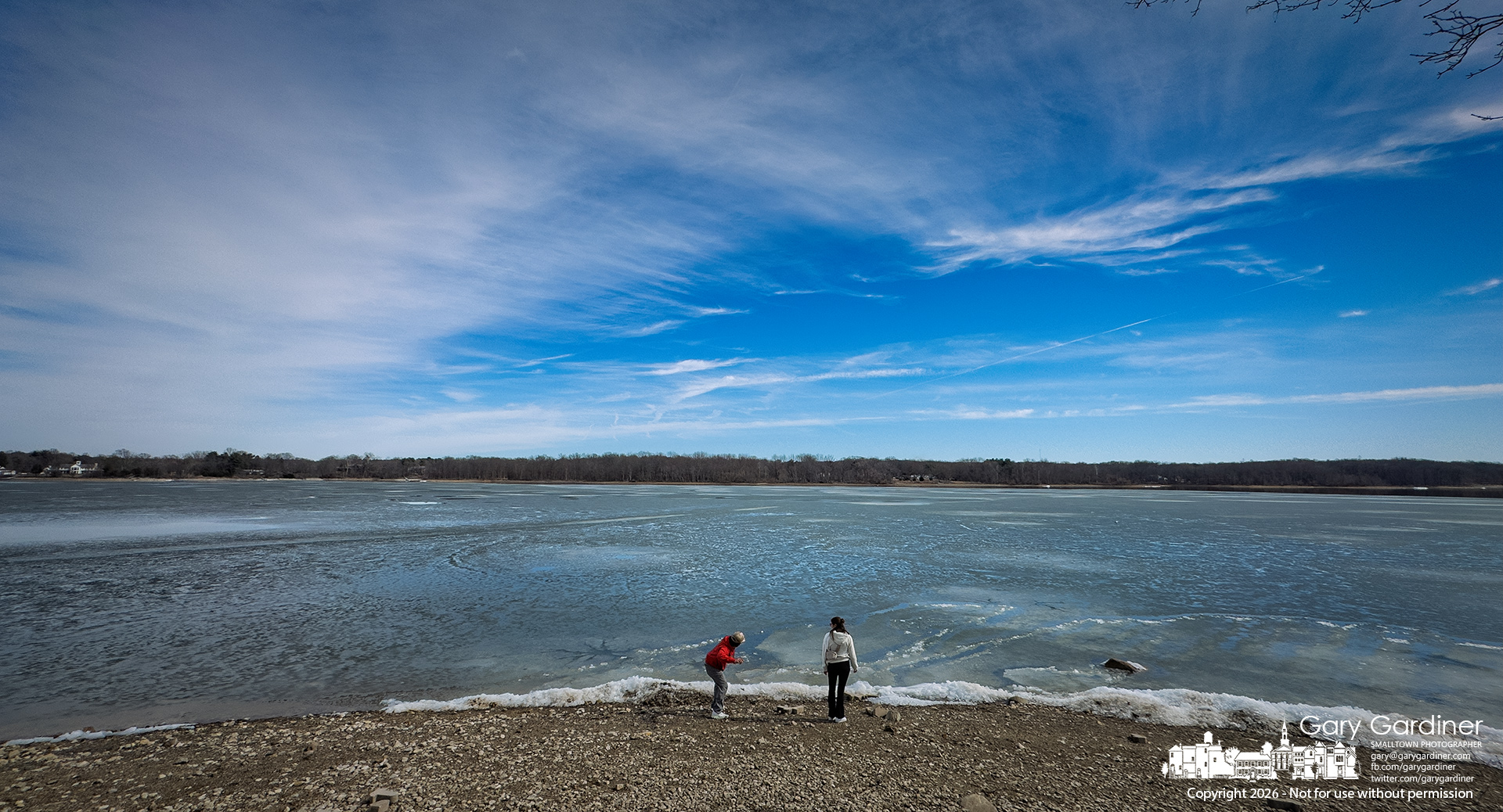 A couple takes turns tossing rocks across the partially frozen surface of Hoover Reservoir. (My Final Photo for February 28, 2026)