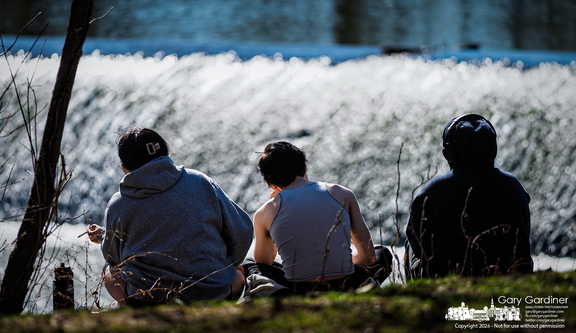 Enjoying a warm Spring-like day, three friends sit on the floodwall below the Alum Creek Dam in Westerville. (My Final Photo for MArch 9, 2026)