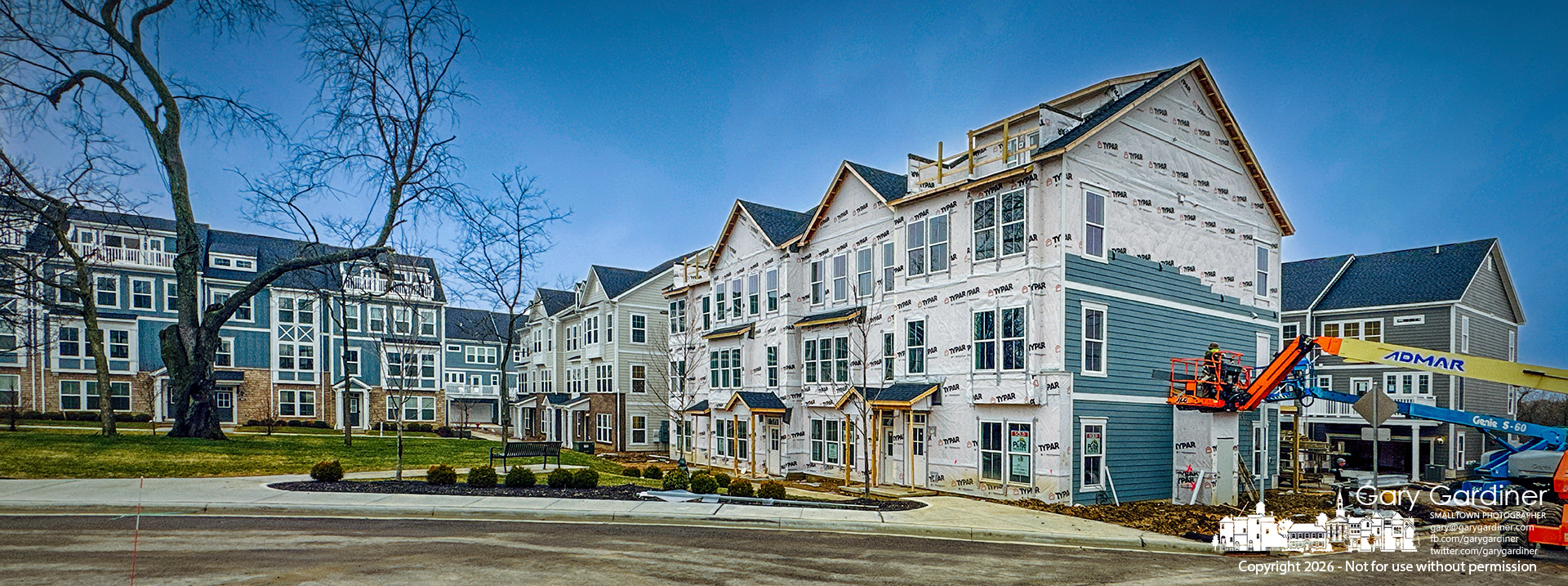 Builders apply siding to one of the townhome clusters at Townhomes on the Greenway on North West Street, being built on former farmland. (My Final Photo for March 4, 2026)