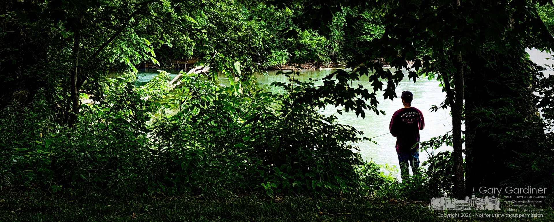 An angler stands in the shadows on a hot afternoon, staying out of the late afternoon sun as he fishes below the dam at Alum Creek Park in Westerville. (My Final Photo for June 9, 2026. Photo by Gary Gardiner)