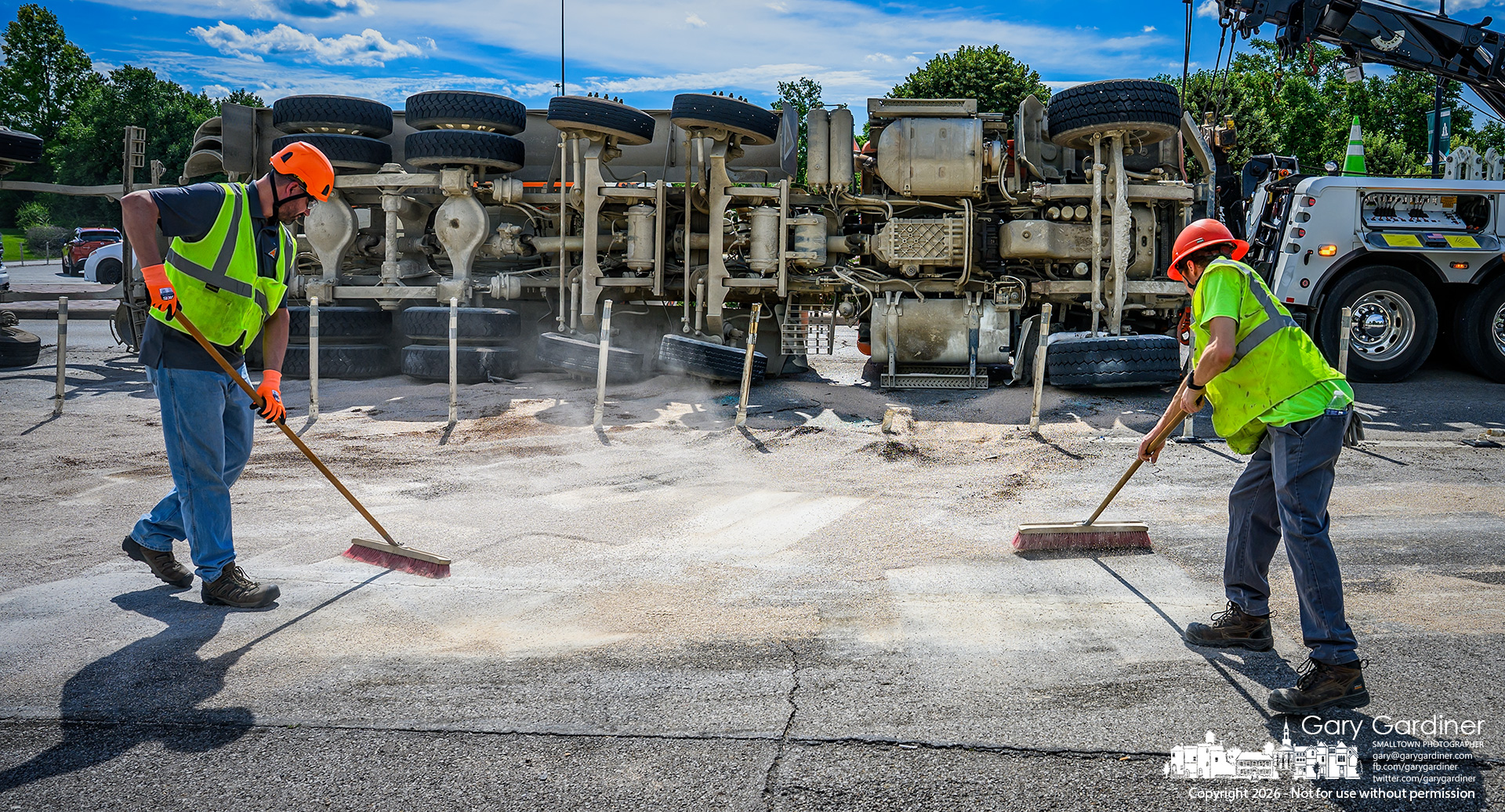 Workers sweep up materials used to soak up hydraulic fluid that leaked from an overturned cement truck that failed to make a turn from I-270 to State Street. (My Final Photo for June 11, 2026. Photo by Gary Gardiner)