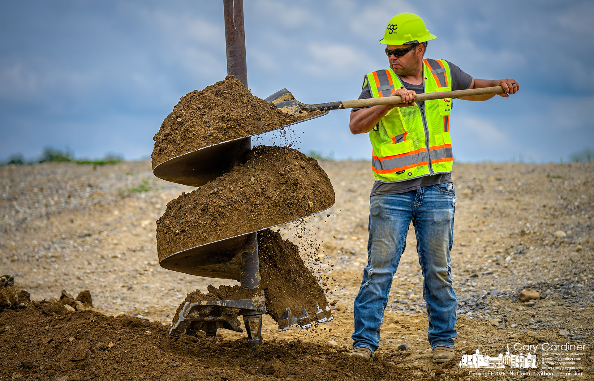 A worker clears soil from an auger drilling a hole for the concrete mount for a traffic signal pole on Africa Road at the extension of Westar Boulevard. (My Final Photo for July 8, 2026. Photo by Gary Gardiner)