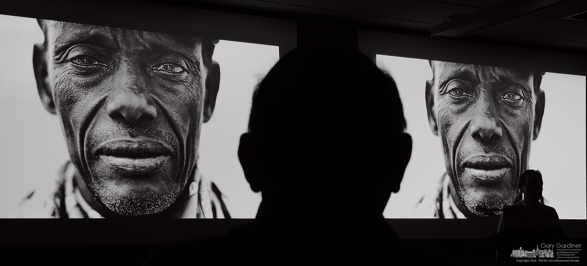 A photographer watches a double-screen slide presentation at the 75th anniversary convention for the Ohio News Photographers Association. (My Final Photo for June 20, 2026)