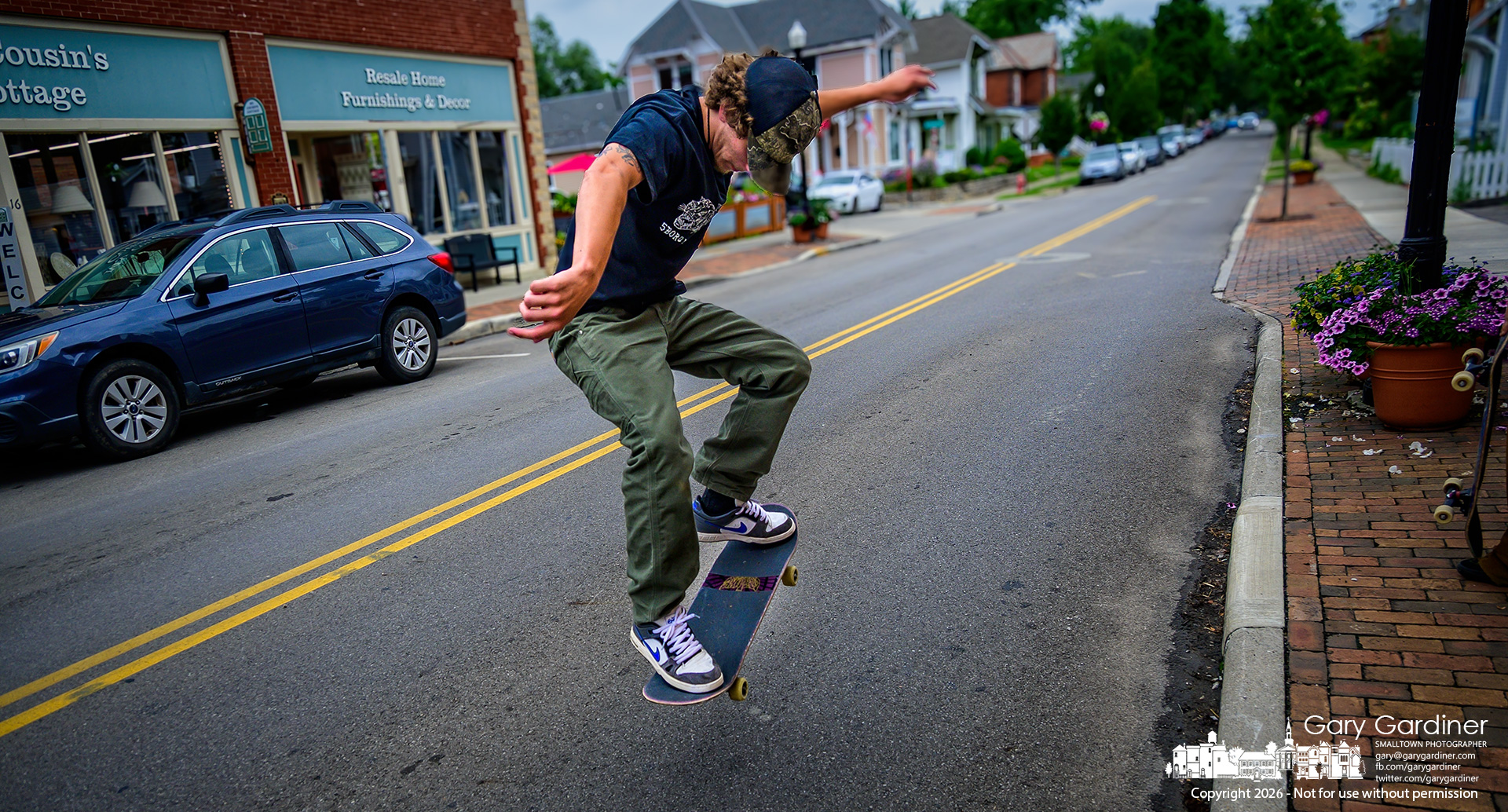 A skateboarder practices a kickflip on East College Avenue in front of Old Skool Skate Shop in Uptown. (My Final Photo for June 27. Photo by Gary Gardiner)