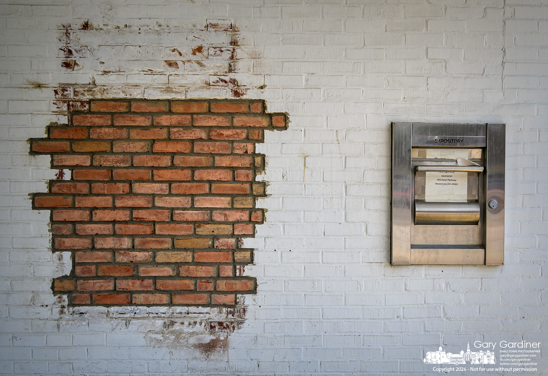 Bricks cover the former ATM opening, and a sign directs depositors to the new bank building at the rear of the Middlefield Bank building in Uptown Westerville. (My Final Photo for July 30, 2026. Photo by Gary Gardiner)