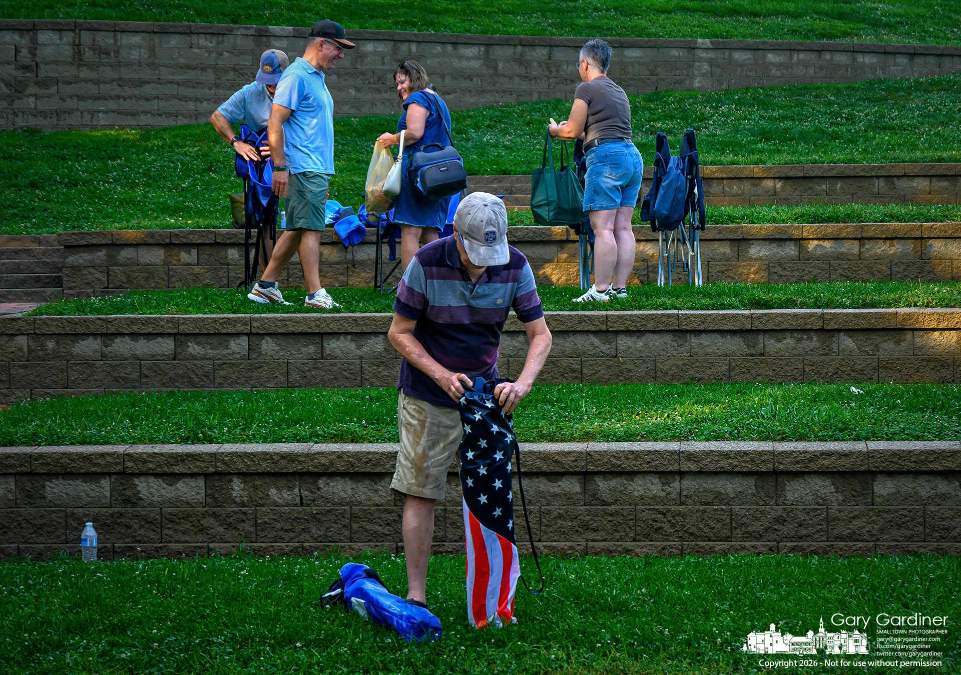 Music lovers gather their chairs and blankets after a rainstorm blanketed the amphitheater at Alum Creek North, just as the Westerville Jazz Orchestra began its Sunday concert. The rain and the report of another storm to follow forced the city to cancel the concert. (My Final Photo for August 9, 20276. Photo by Gary Gardiner)